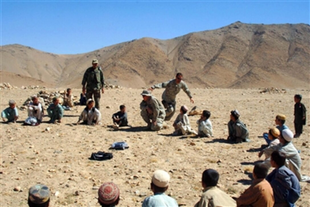 U.S. Army soldiers play a game of "Duck, Duck, Goose" with a group of children in Charkh, Afghanistan, Oct. 6, 2006, during a medical and veterinarian civic action program.  