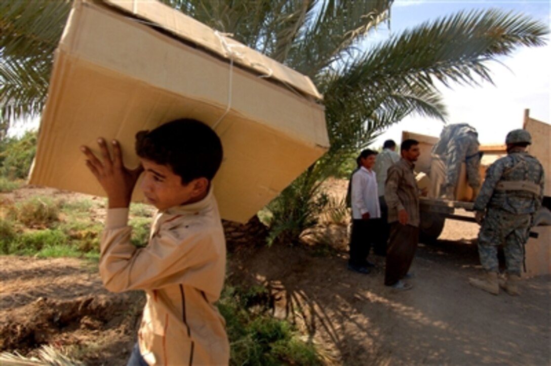 Students and staff members of the Sayeed Ibraheem School help U.S. Army soldiers from the 412th Civil Affairs Unit, unload supplies donated to the school in Seddah, Iraq, Oct. 3, 2006. 