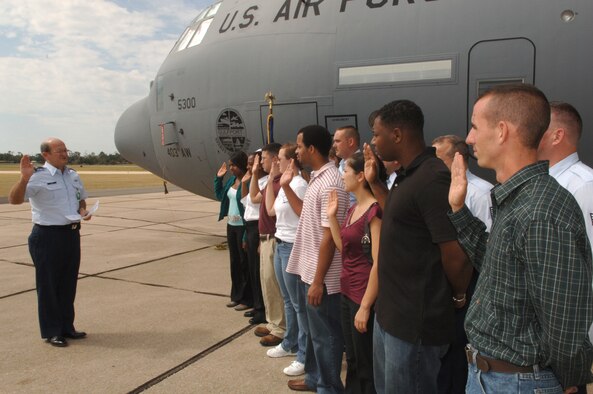 Brig. Gen. Richard Moss, commander, 403rd Wing, renders the oath of enlistment to a group of Air Force Reserve enlistees. The mass enlistment, held on the Keesler Air Force Base flight line, was set up by the 403rd Recruiting Squadron. Recruiters from the squadron stand behind the new Reservists as they take the oath. The 403rd Wing's newly named aircraft the "Spirit of Gulfport" served as the backdrop for the ceremony. Enlistees and their families also toured the aircraft.