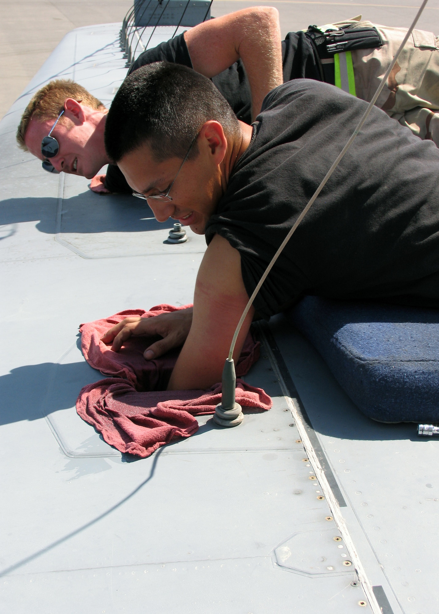 Staff Sgt. Mauricio Moya and Airman 1st Class Joshua Rowles repair an antenna element on an EC-130 Hercules.  Sergeant Moya is an aerospace propulsion mechanic and Airman Rowles is a crew chief.  Both Airmen are deployed to the 386th Expeditionary Aircraft Maintenance Squadron at a base in Southwest Asia.  (U.S. Air Force photo/Capt. Jeff Clark)