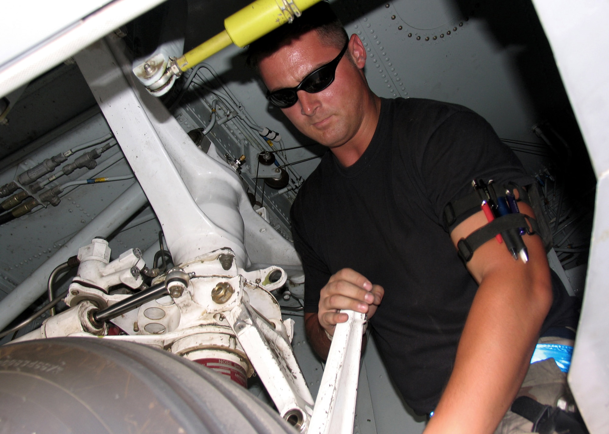 Senior Airman Jason Tettmar disconnects the nose gear scissors on an EC-130 Hercules to prepare the aircraft for towing. Airman Tettmar is a crew chief deployed to the 386th Expeditionary Aircraft Maintenance Squadron at a base in Southwest Asia.  (U.S. Air Force photo/Capt. Jeff Clark)