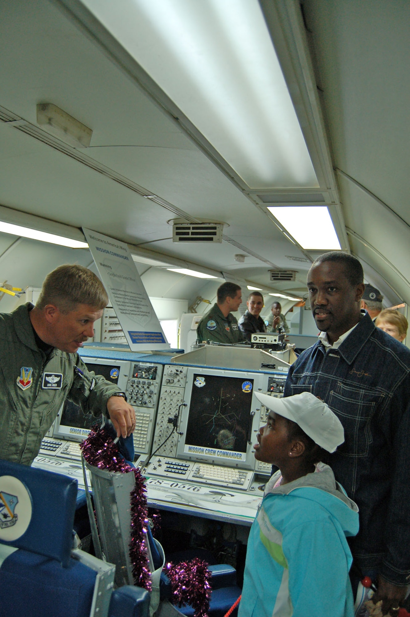 (Right to left) Dover resident John Garvey and his daughter Cyndi speak with Lt. Col. Dave Breen, 960th Airborne Air Control Squadron mission crew commander, about the capabilities of the E-3 Sentry Airborne Warning and Control System during a static display tour through the aircraft Saturday. The aircraft – commonly referred to as an AWACS – and its crew are stationed at Tinker Air Force Base, Okla. (U.S. Air Force photo/Staff Sgt. James Wilkinson)