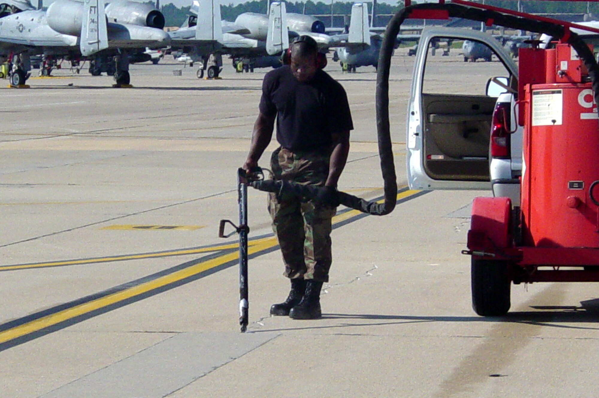 Staff Sgt. Adegboyega Adeyemo, 43rd Civil Engineer Squadron, takes advantage of the empty ramp space created by the A-10 deployment to repair some of the cracks and missing seals as part of the annual maintenance of the ramp. Sergeant Adeyemo uses a Crafco hot sealing machine to apply sealant directly into the crack that he previously routed and cleaned. The next step will be repair of the many minor spalls across the ramp. (U.S. Air Force photo/Maj. Erik Lagerquist)