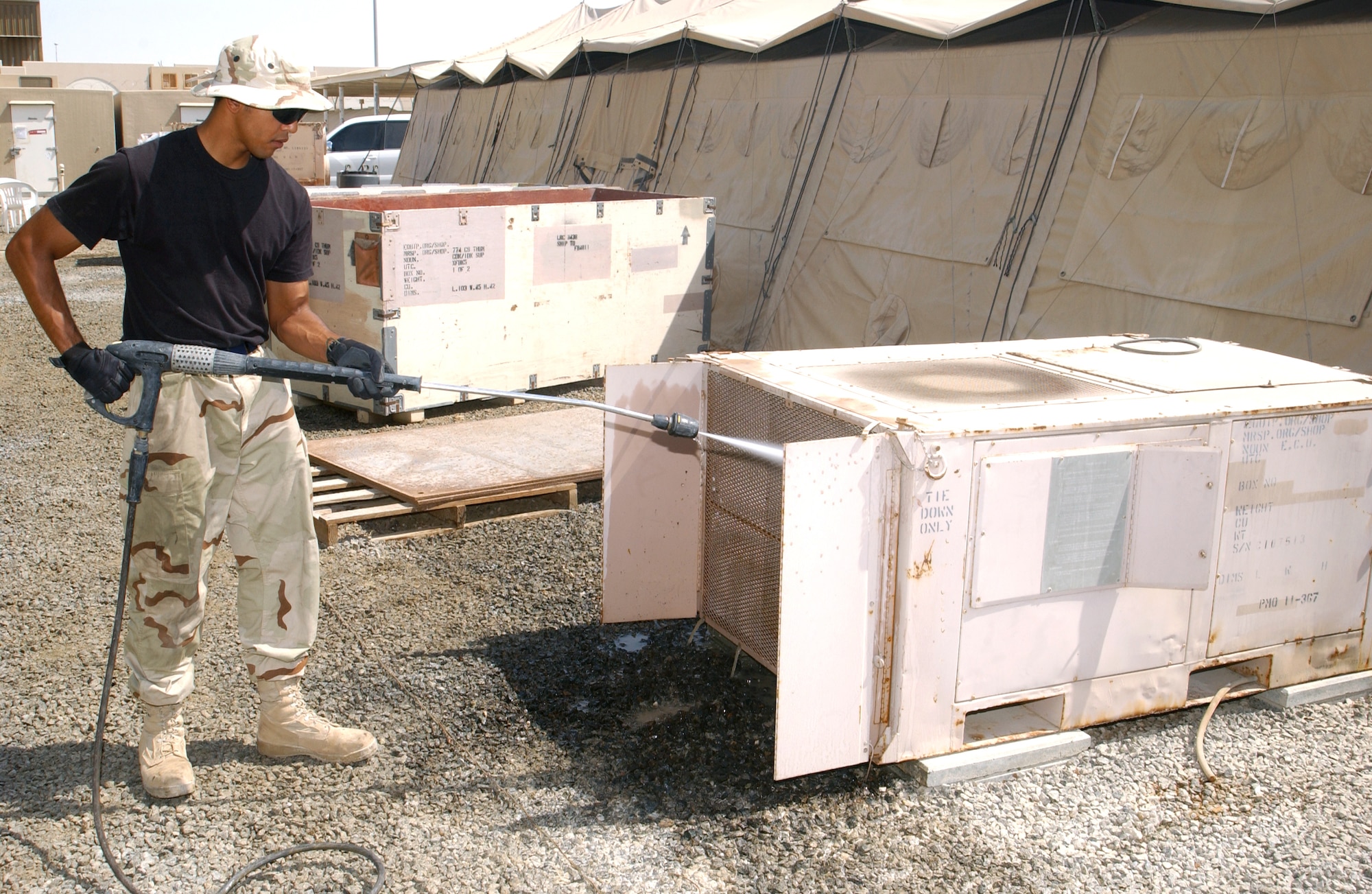 Senior Airman Robert George sprays the coils of an air-conditioning unit with water outside one of the dining facilities at this deployed location in Southwest Asia Oct. 11. The water rinses off hydrochloric acid used previously to clean sand, grit and debris from the unit's coils, which are much like that of an automobile radiator. There are better than 3,000 air-conditioning units at this base, which is home to about 1,500 Airmen and the 380th Air Expeditionary Wing. Airman George is assigned to the 380th Expeditionary Civil Engineer Squadron and deployed from Yokota Air Base, Japan. (U.S. Air Force photo/Master Sgt. Jason Tudor)
