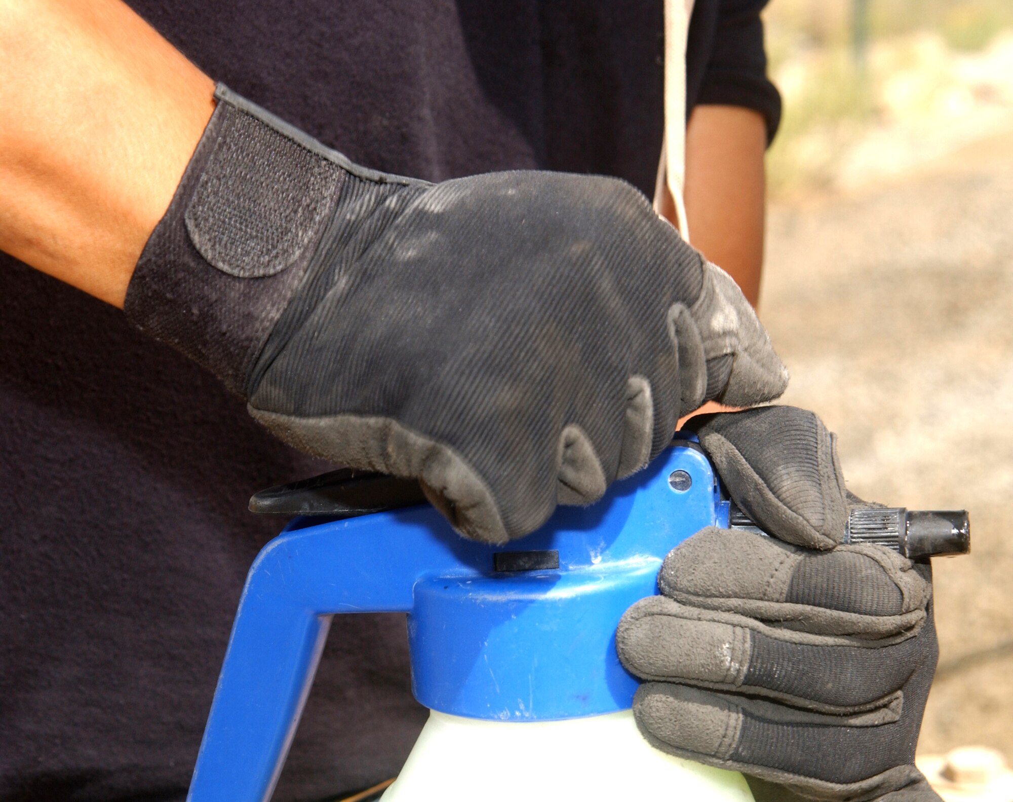 Staff Sgt. Ramir Manaloto pressurizes a jug of hydrochloric acid before spraying it onto the coils of an air-conditioning unit outside one of the dining facilities of this deployed location in Southwest Asia Oct. 11. The acid cleans sand, grit and debris from the unit's coils, which are much like that of an automobile radiator. There are better than 3,000 air-conditioning units at this base, which is home to about 1,500 Airmen and the 380th Air Expeditionary Wing. Sergeant Manaloto is assigned to the 380th Expeditionary Civil Engineer Squadron and deployed from Yokota Air Base, Japan. (U.S. Air Force photo/Master Sgt. Jason Tudor)
