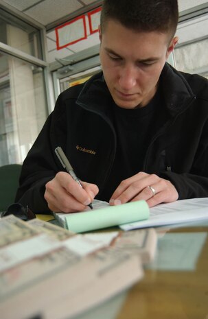 Capt. Jonathan Czarney writes out a purchase order for fuel at a meeting here Oct. 8. The captain, a contingency contracting officer, is deployed here from McChord Air Force Base, Wash., as part of a 50-person team bringing rebuilding supplies to remote villages devastated by a 7.6 magnitude earthquake last year. (U.S. Air Force photo/Senior Airman J.G. Buzanowski)                              