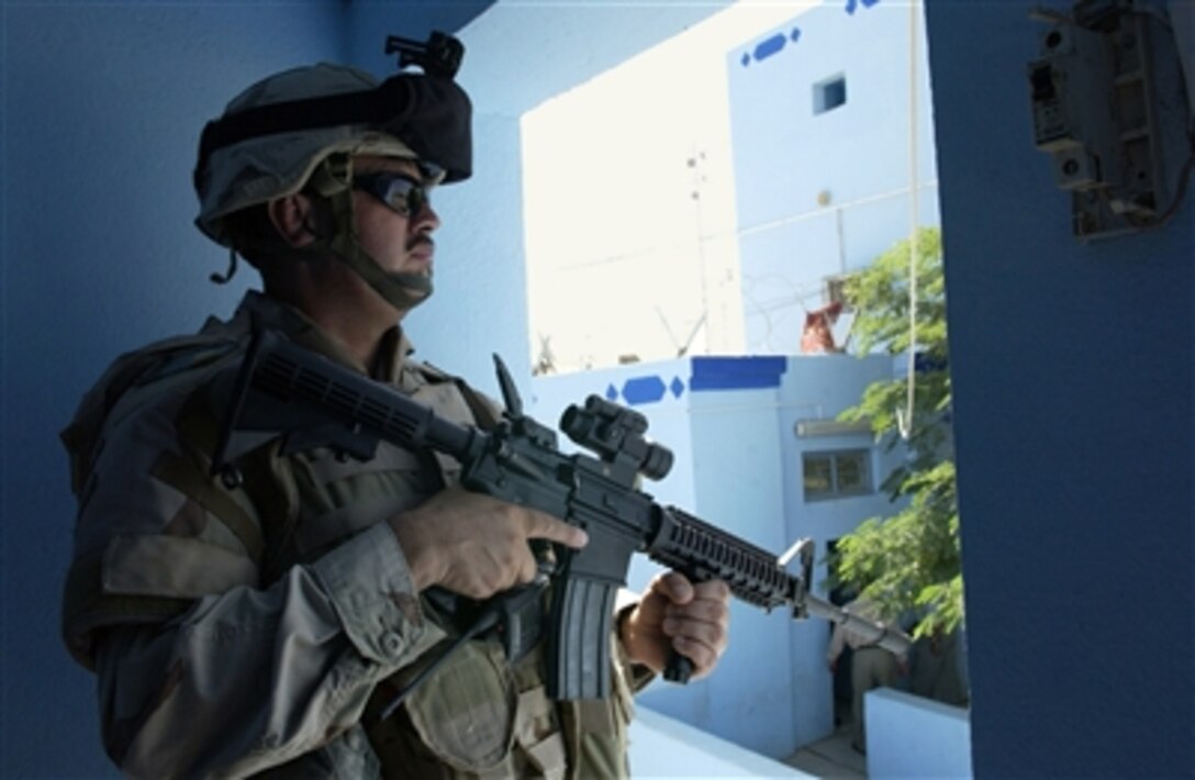 U.S. Army Sgt. Roberto Herrera provides security from a tower position at the Ad Diwaniyah, Iraq, police department on Oct. 8, 2006.  Other soldiers with Herrera's team are meeting with the chief of the police station.  Herrera is assigned to the Police Transition Team, 89th Military Police Brigade.  