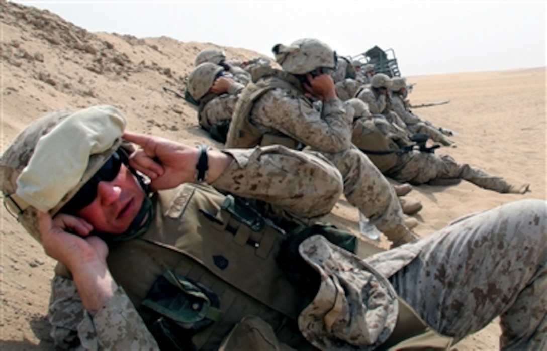 U.S. Marine Corps Gunnery Sgt. Carl Zador and other Marines from Marine Expeditionary Unit Service Support Group 24, duck behind the berm before an explosive charge is detonated during  training near Camp Virginia, Kuwait, Oct. 11, 2006.   