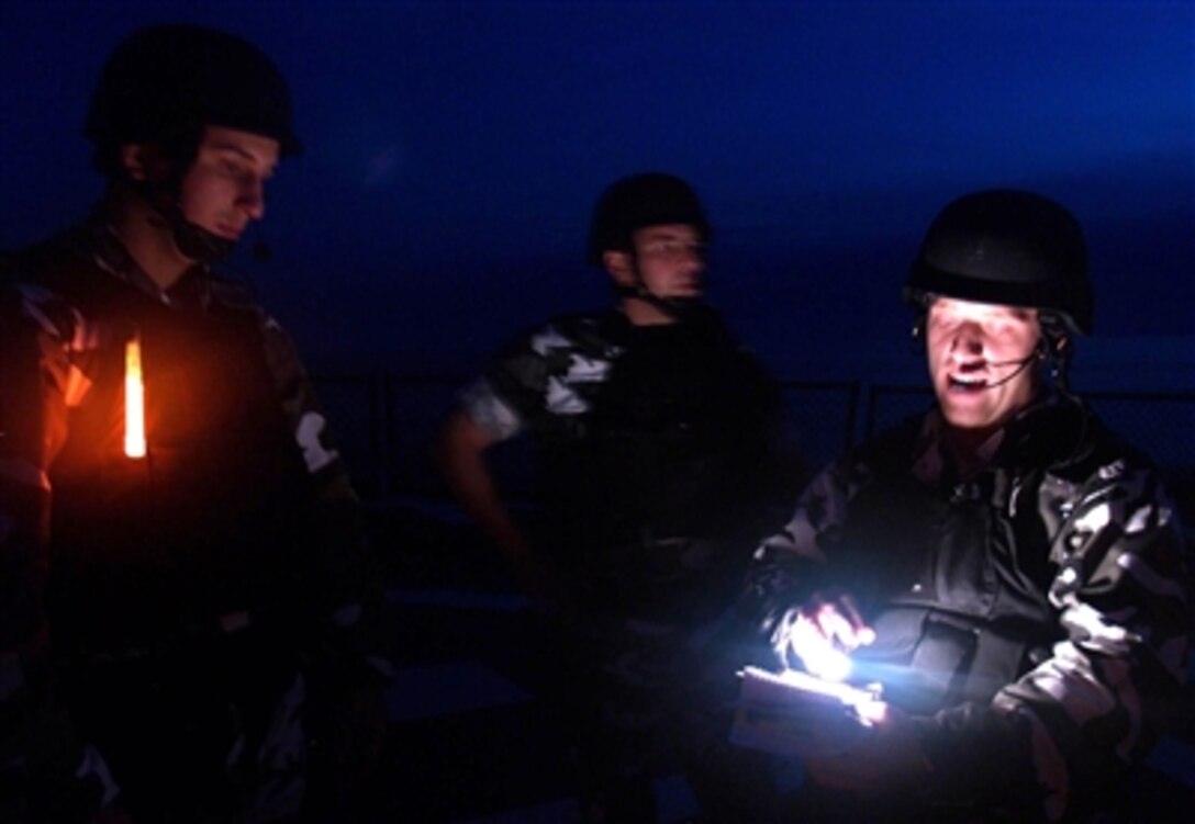 Ensign James Dickey assigned to the guided missile destroyer USS Ross, right, briefs the members the ship's Visit, Board, Search and Seizure team before conducting a boarding exercise in the Gulf of Lion, Mediterranean Sea, Oct. 9, 2006.  