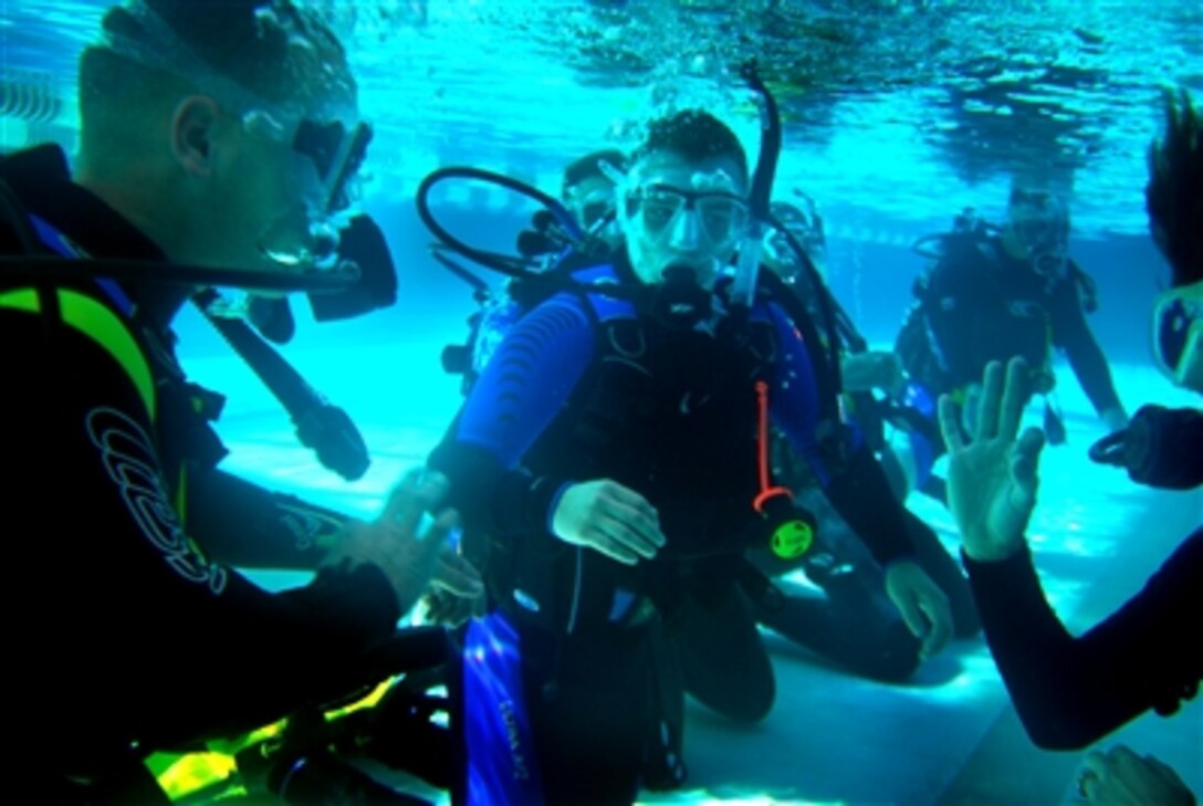 Lucin Broekhuizen, right, a diving instructor with AA Diving at Marine Corps Base Camp Lejeune, N.C., flashes Lance Cpl. Chris Boreland the OK sign while they practice scuba drills with other Marines from the Wounded Warrior Barracks, Oct. 3, 2006. 