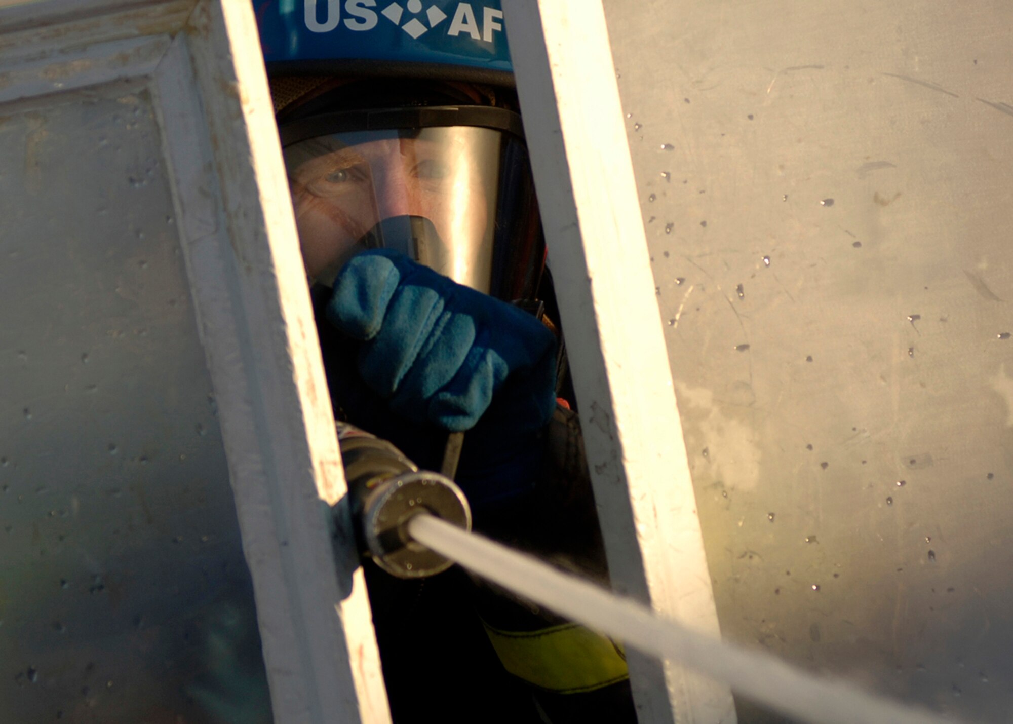 Dave Chiodo, Team Travis, crashes through some make shift doors to spray a target with a fire hose during the Firefighter Combat Competition at Morrow, Ga., Oct. 13, 2006.  (U.S. Air Force photo/Tech. Sgt. Cecilio M. Ricardo Jr.)