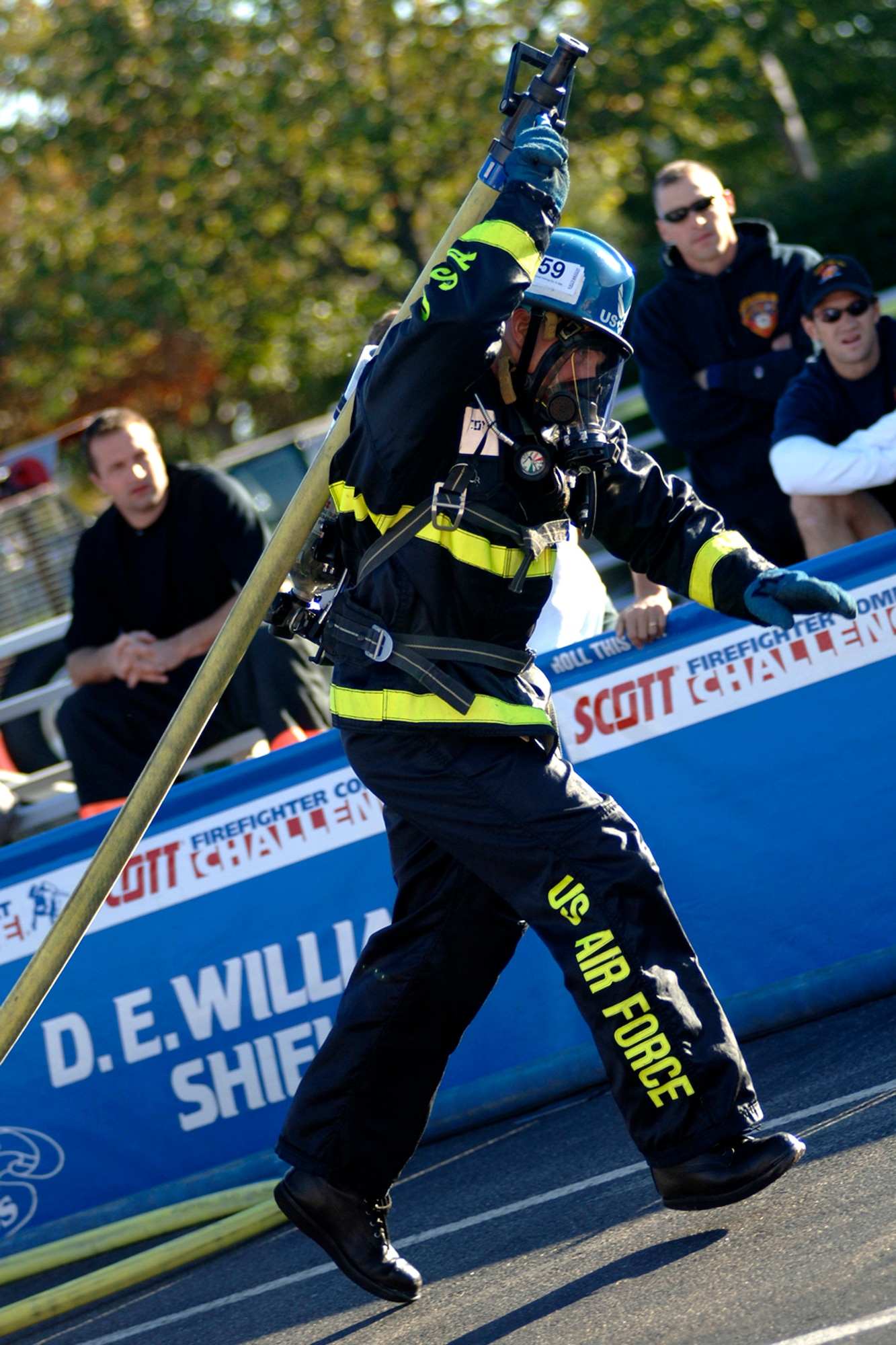 Tech. Sgt. Mike Melton, Team Travis, grabs the fire hose and runs 20 feet through some make shift doors to spray a target during the Firefighter Combat Competition at Morrow, Ga., Oct. 13, 2006.  (U.S. Air Force photo/Tech. Sgt. Cecilio M. Ricardo Jr.)