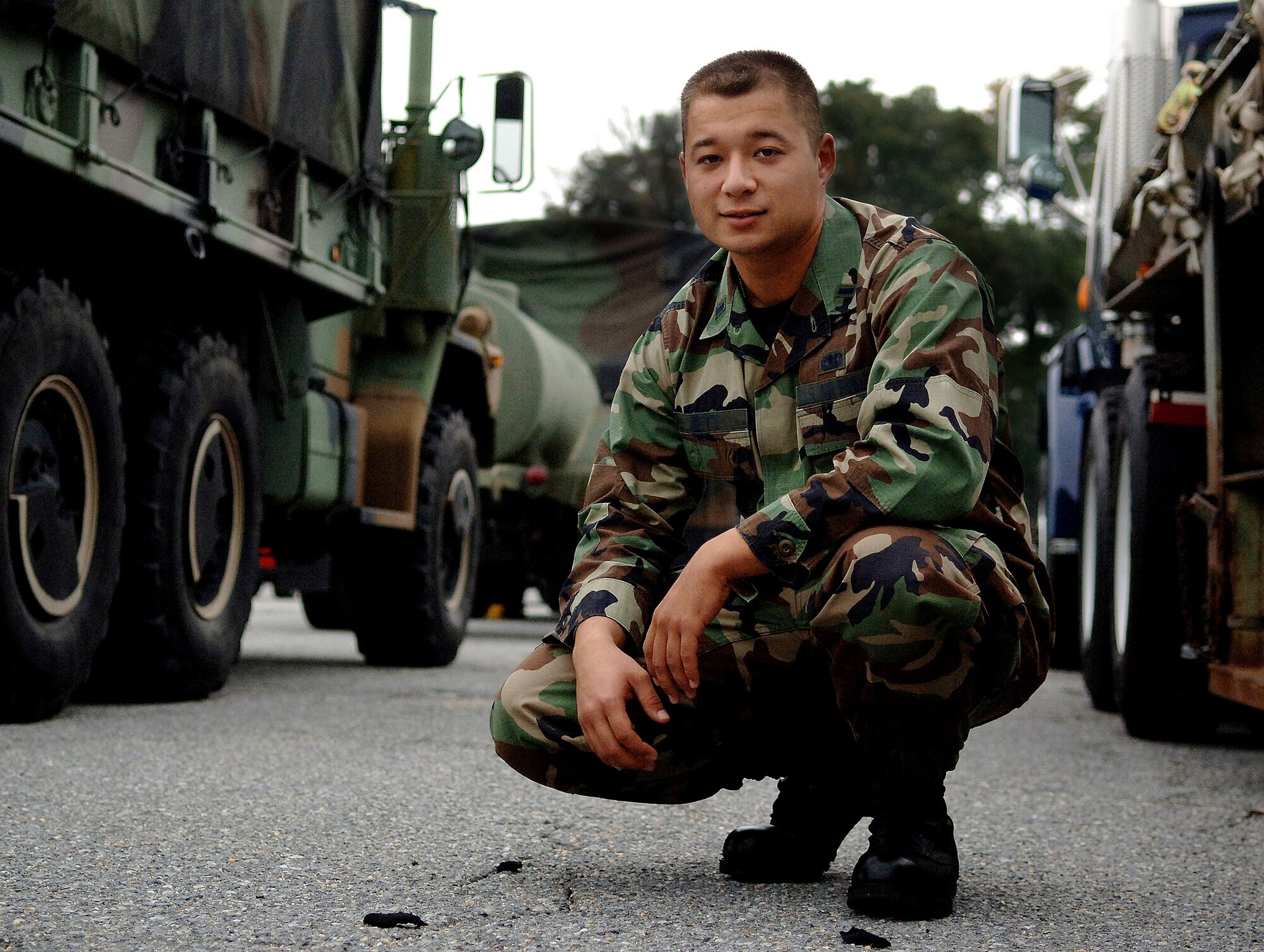 1st Lt. Shaenan Jett coruches between vehicles Oct 11 at Andrew Air Force Base, Md. Lieutenant Jett is a flight commnader with the 316th Logistics Readiness Squadron. He is involved with the Air Force Memorial dedication ceremony Oct. 14 in Arlington, Va. (U.S. Air Force photo/Tech. Sgt. Larry A. Simmons)