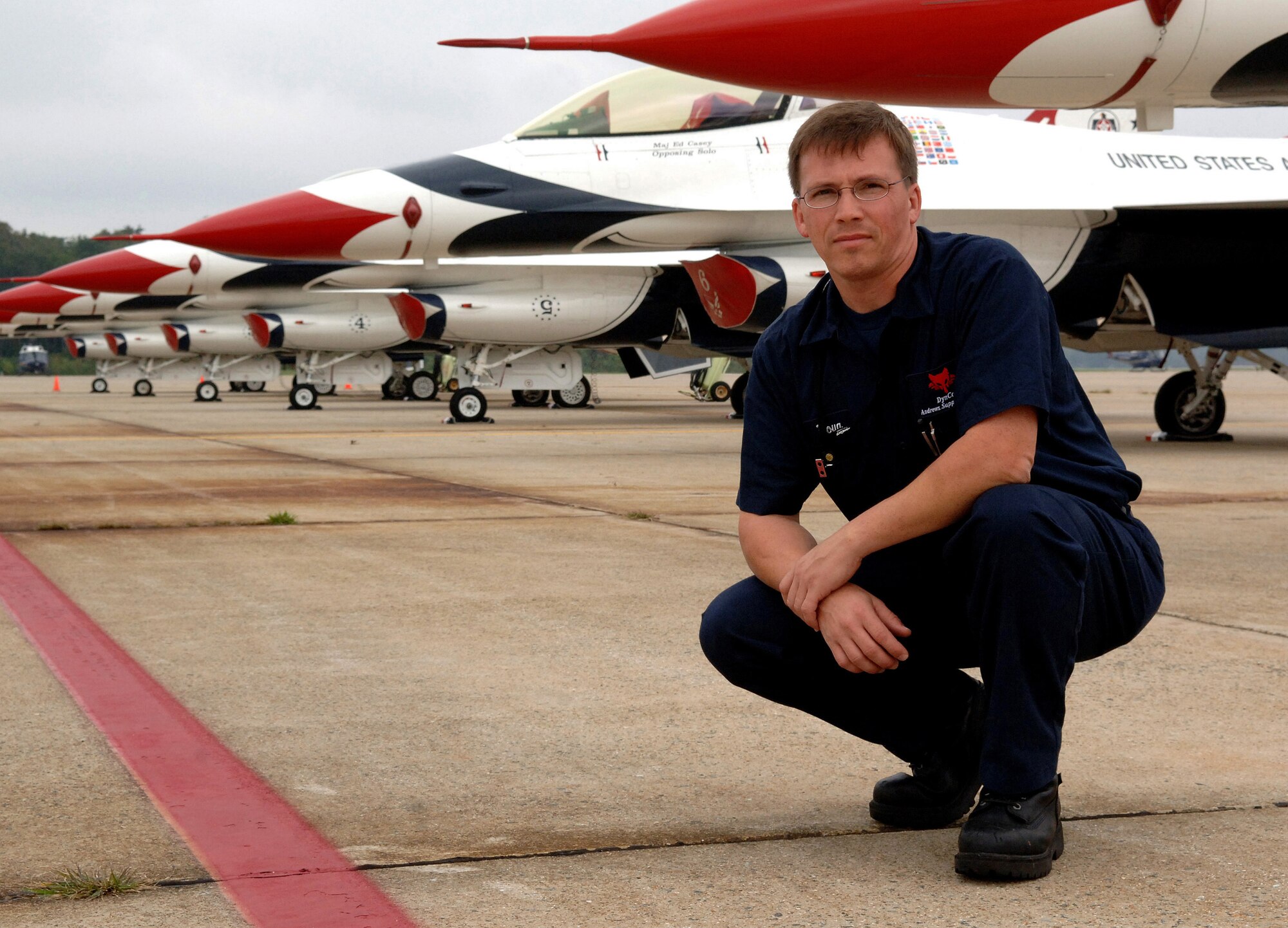 Douglas Landgraf crouches in front of the U.S. Air Force Thunderbirds aircraft Oct. 11 at Andrews Air Force Base, Md. Mr. Landgraf is an aircraft mechanic and ramp coordinator with the 89th Airlift Wing at Andrews AFB and is involved with the Air Force Memorial dedication ceremony Oct. 14 in Arlington, Va. (U.S. Air Force photo/Tech. Sgt. Larry A. Simmons)