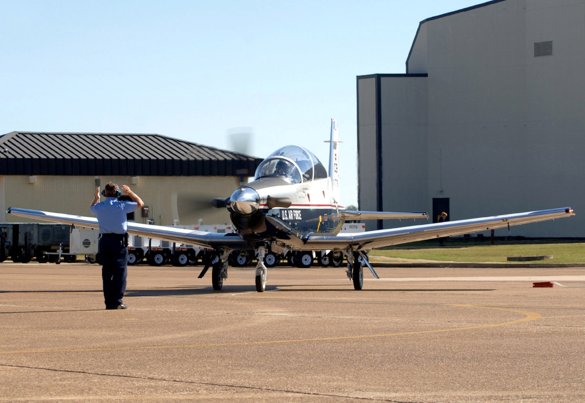Lt. Col. Todd White taxis in with the first T-6 Texan assigned to the fleet at Columbus Air Force Base, Miss., fleet before presenting Col. Eric Theisen with the keys to the aircraft. Colonel White is the 41st Flying Training Squadron commander, and Colonel Theisen is the 14th Operations Group commander at Columbus AFB. (U.S. Air Force photo/Senior Airman Cecilia Rodriguez)