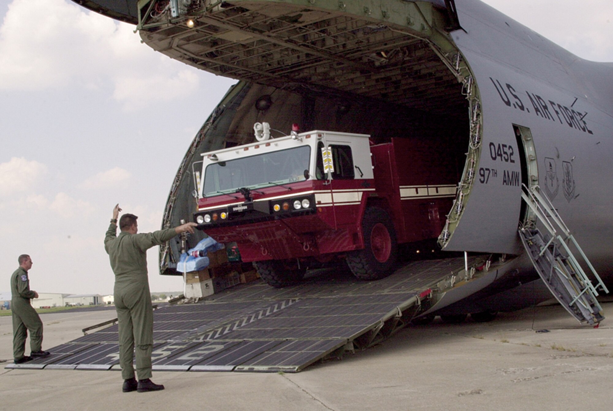 GOODFELLOW AIR FORCE BASE, Texas (AETCNS) -- Senior Master Sgt. Robert Hoeppner, a loadmaster with the 56th Airlift Squadron at Altus AFB, Okla., signals the driver of a P-19 fire truck as it is loaded into a C-5 Galaxy aircraft at San Angelo's Mathis Field last week. Goodfellow AFB provided two fire trucks and a maintenance vehicle for the Hurricane Katrina relief efforts. (U.S. Air Force photo by Airman Luis H. Loza Gutierrez) 