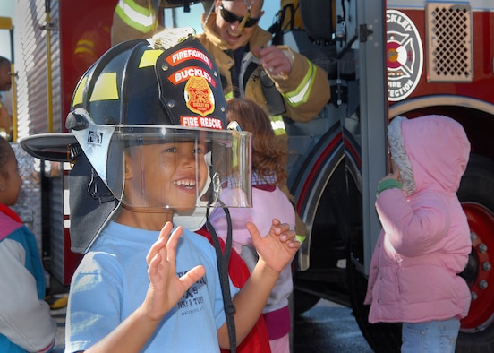 BUCKLEY AIR FORCE BASE, Colo. -- Four-year-old Jacob Wright tries on a hat belonging to one of base fire fighters during the fire department's visit with their mascot, Sparky the Fire Dog, to the Child Development Center here Oct. 12. The fire fighters visited the children to teach them about fire saftey and to show them their equipment. Visiting the CDC was one of the events planed for Fire Prevention Week on the base. (U.S. Air Force photo by Senior Airman Steve Czyz)
