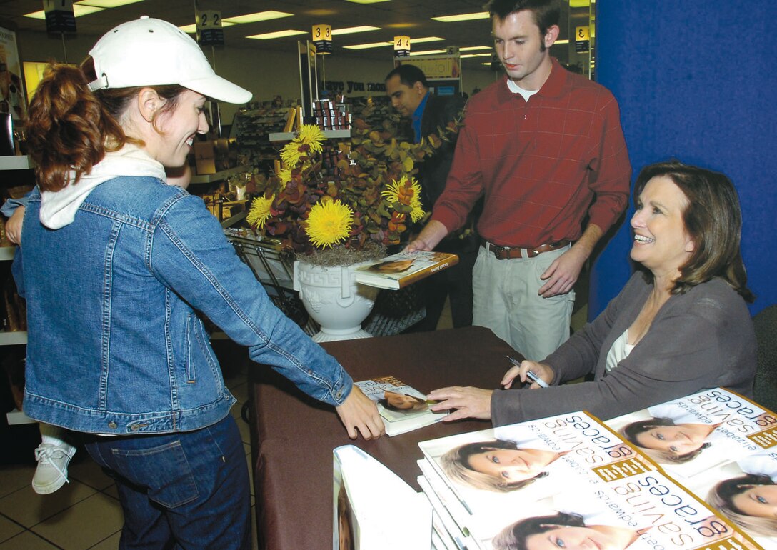 Allyson J. Fairweather and her son, Brendan, 1, were among a crowd of Andrews patrons to stand in line to have books autographed by Elizabeth Edwards, author of "Saving Graces: Finding Solace and Strength from Friends and Strangers," at the Base Exchange Oct. 6. Mrs. Edwards is the wife of John Edwards, former senator from North Carolina and a vice presidential candidate in 2004. Mrs. Fairweather is the wife of Capt. Brian J. Fairweather, 99th Airlift Squadron pilot.