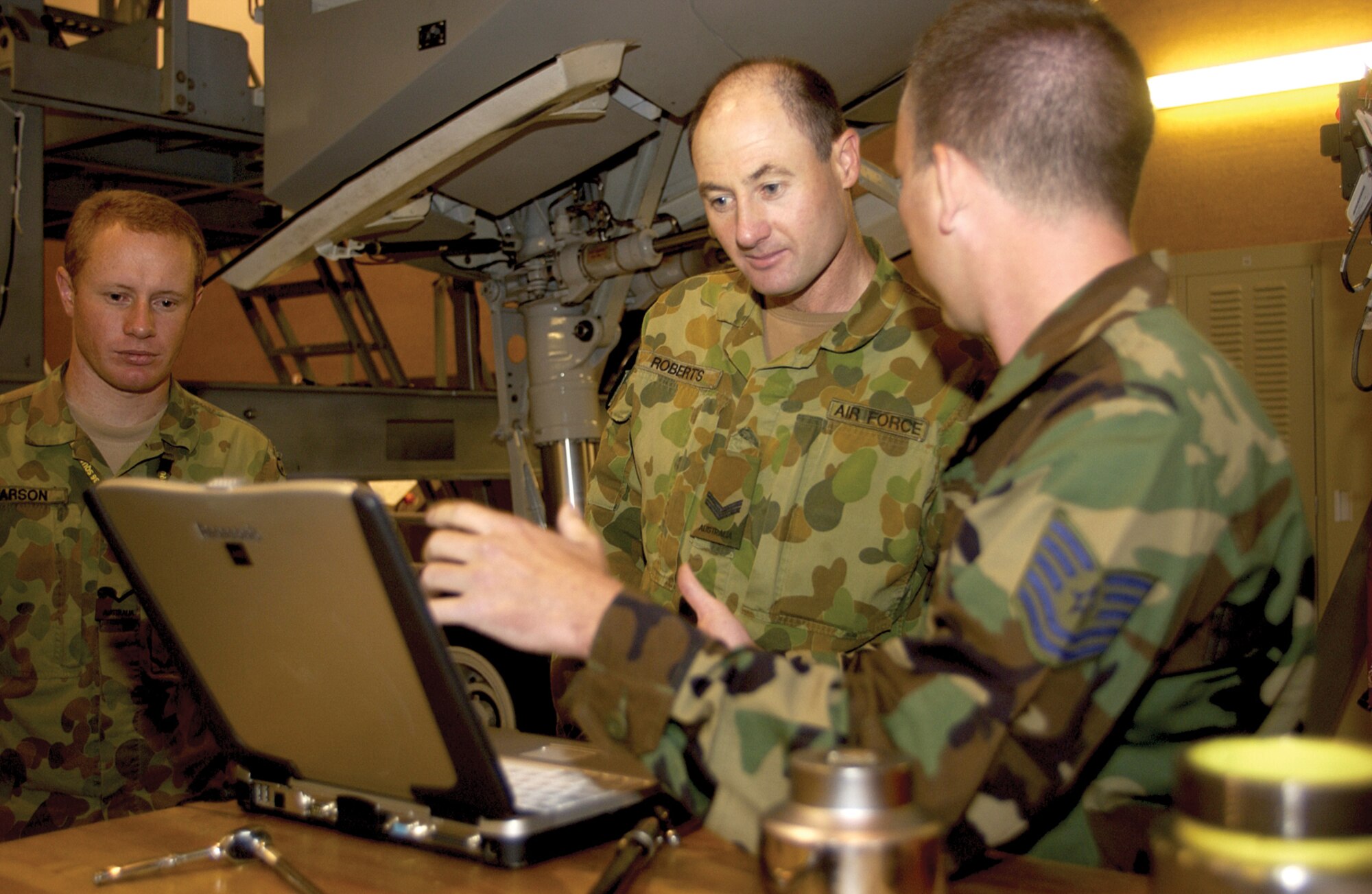 Royal Australian Air Force Cpl. David Roberts (center) and Leading Aircraftsman Michael Clarson (left), go over computer-based technical orders with Tech. Sgt. Troy Barber, 373rd Training Squadron Detachment 5, at the 373 DET. 5 training building Sept. 29. Twenty-four RAAF members have been at Charleston AFB since July 31 receiving training on C-17 maintenance procedures.  (U.S. Air Force photo/Airman 1st Class Sam Hymas)