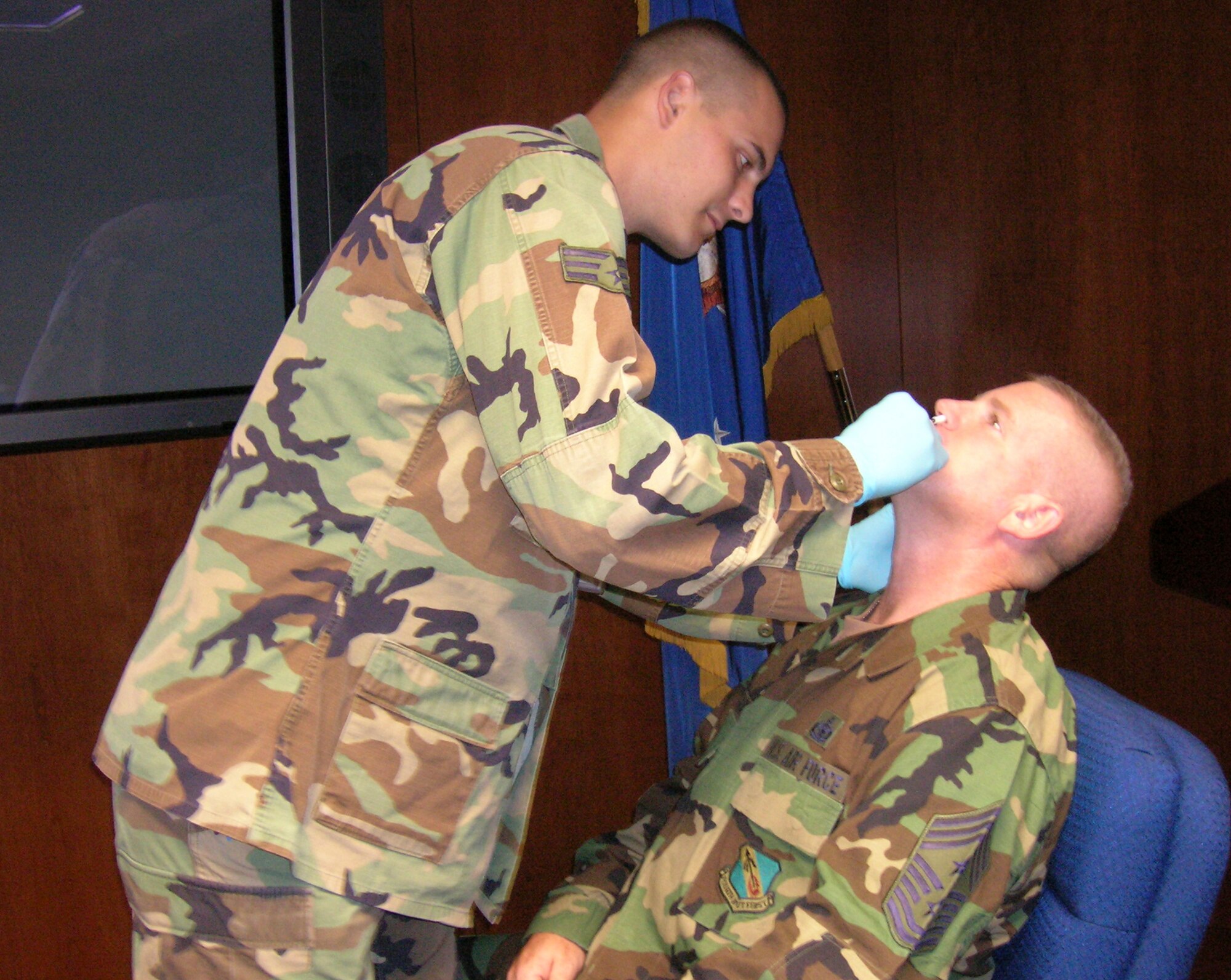 Senior Airman Jeremy Means, emergency medical technician, gives Chief Master Sgt. Layton Clark, 4th Fighter Wing command chief master sergeant, a FluMist vaccination Oct. 6.  (U.S. Air Force photo by Robin DeMark)          