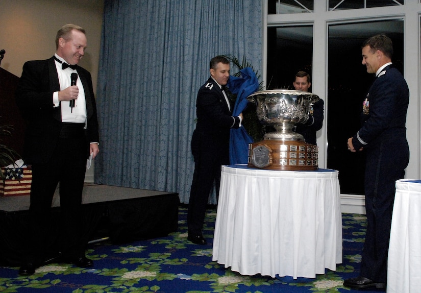 Dr. Thomas Kennedy, vice president of Integrated Airborne Systems for Raytheon’s Space and Airborne Systems, presents Lt. Col. Robert Garland, 71st Fighter Squadron commander, Col. Thomas Bergeson; 1 Operations Group  commander, and Brig. Gen. Burton Field, 1st Fighter Wing commander, with the Raytheon Trophy Oct. 6 at a celebration dinner held at the Kingsmill Resort in Williamsburg.  The 71st FS was awarded the coveted Raytheon Trophy for outstanding aerial achievement for a record fifth time. (Photo by Senior Airman Austin Knox)