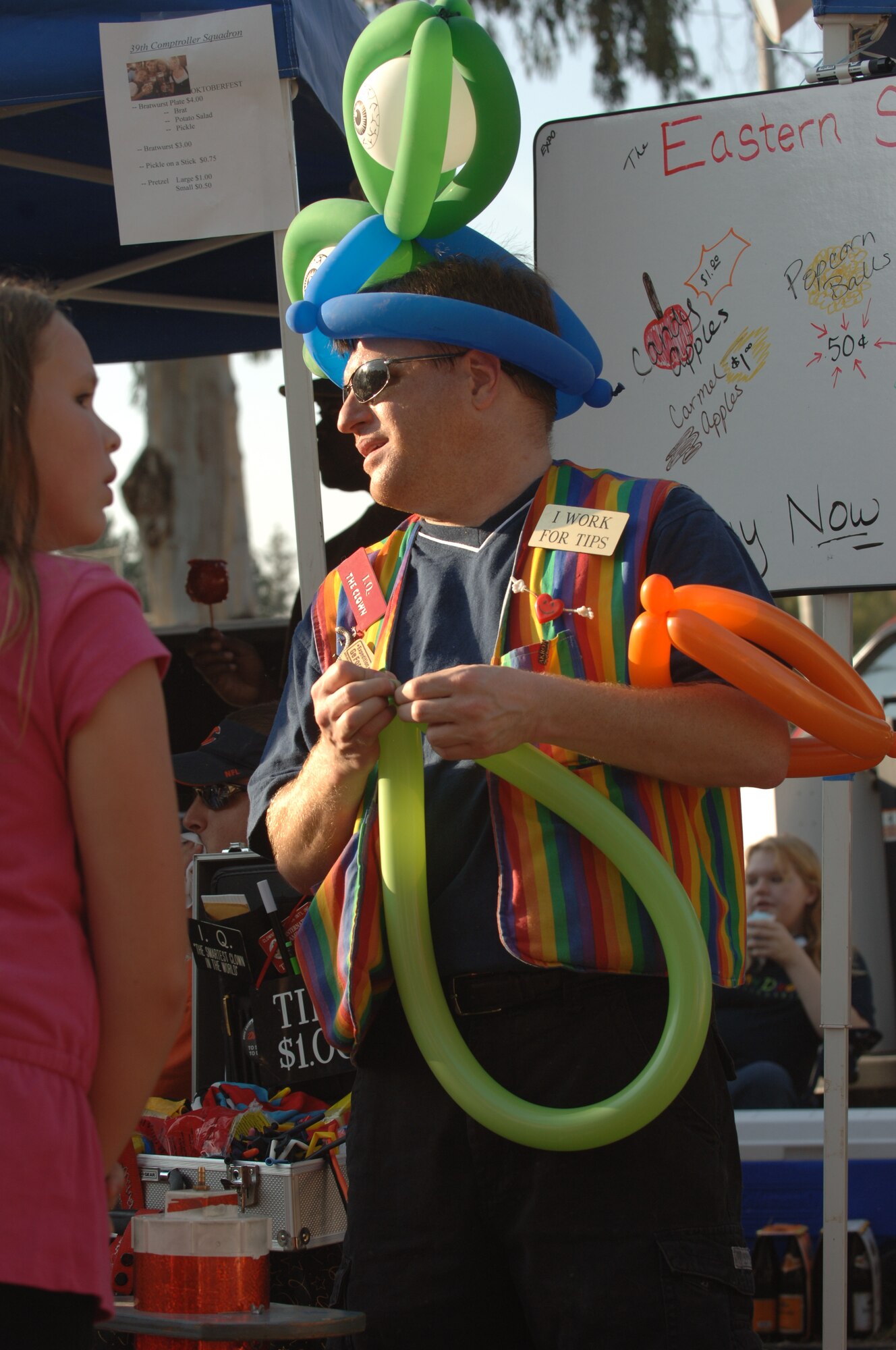 Senior Master Sergeant Thomas Benson, 39th Comptroller Squadron superintendent, makes balloon animals for a young girl during Octoberfest. (U.S. Air Force photo by Airman Nathan Lipscomb)