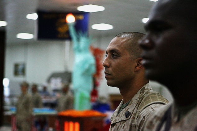 Brooklyn, NY. native Gunnery Sgt. Edwardo Espinal, a 32-year-old staff noncommissioned officer in charge of initial issue provisioning, Combat Logistics Regiment 15, 1st Marine Logistics Group, stands at attention during the Marine Corps Hymn.  Standing beside Espinal is one of his junior Marines, Lance Cpl. Tierra D. Paught, a warehouse clerk for IIP, CLR 15, 1st MLG, and a 25-year-old native of Chicago.  Talking with the older service members without so much regard to rank helps communication, and helps the senior enlisted and officers show their junior service members support, said Seaman Christopher L. Daniel, a 20-year-old corpsman with Military Police Company, CLR-15, 1st MLG and a native of Barnesville, Ga.