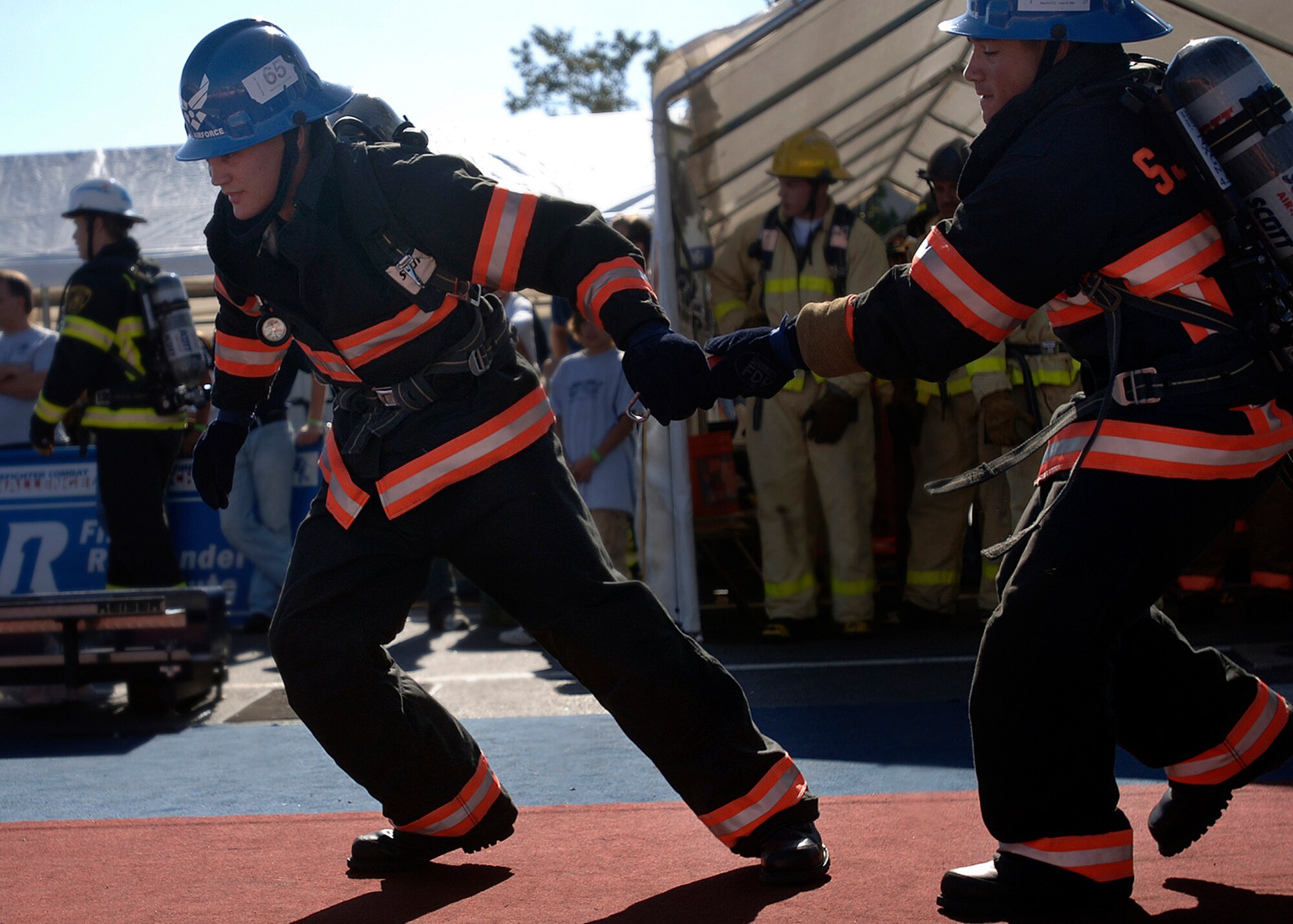 Staff Sgt. Keith Hutton passes a flash light to Airman 1st Class Joshua Huff during the relay race portion of the Firefighter Combat Competition at Morrow, Ga., Oct. 13, 2006.  The competition is a national competition with over 450 firefighters from around the US.  (U.S. Air Force photo/Tech. Sgt. Cecilio M. Ricardo Jr.)