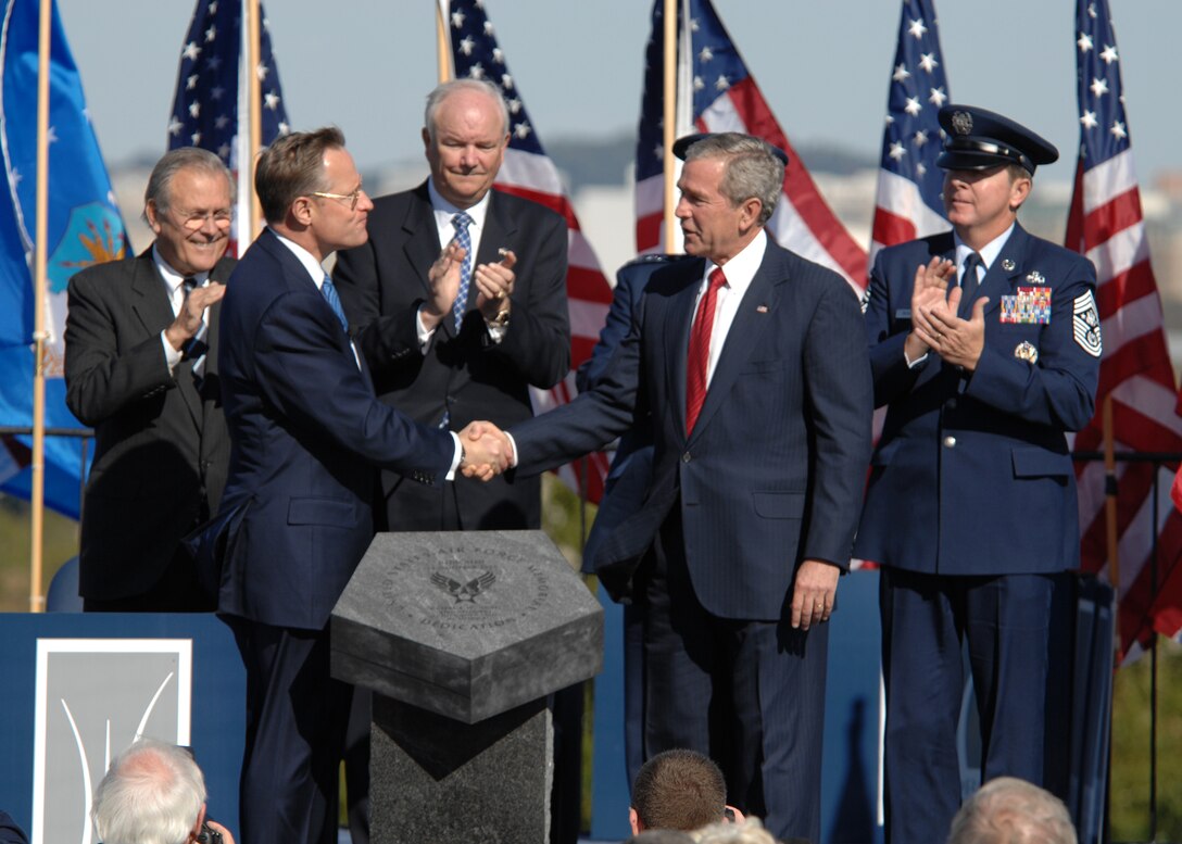 On behalf of all American citizens President George W. Bush accepts the Air Force Memorial from Air Force Memorial Foundation Chairman  Ross Perot Jr. during a dedication ceremony at its Arlington, Va. location overlooking the Pentagon on Saturday, Oct. 14, 2006. Looking on are, from left: Secretary of Defense Donald Rumsfeld, Secretary of the Air Force Michael W. Wynne, Air Force Chief of Staff Gen. T. Michael Moseley and Chief Master Sgt. of the Air Force Rodney J. McKinley. Designed by the late James Ingo Freed the memorial with its three soaring spires inspired by the U.S. Air Force Thunderbirds bomb burst manuever, pays tribute to and honors the patriotic men and women of the U.S. Air Force and its predeccessor organizations. An open house will run near the Pentagon in conjunction with the dedication ceremony which will feature performances by the U.S. Air Force Band, the U.S. Air Force Honor Guard drill team, and will culminate with a concert featuring country music performer LeeAnn Womack. (U.S. Air Force photo/Tech. Sgt. Cohen Young) 