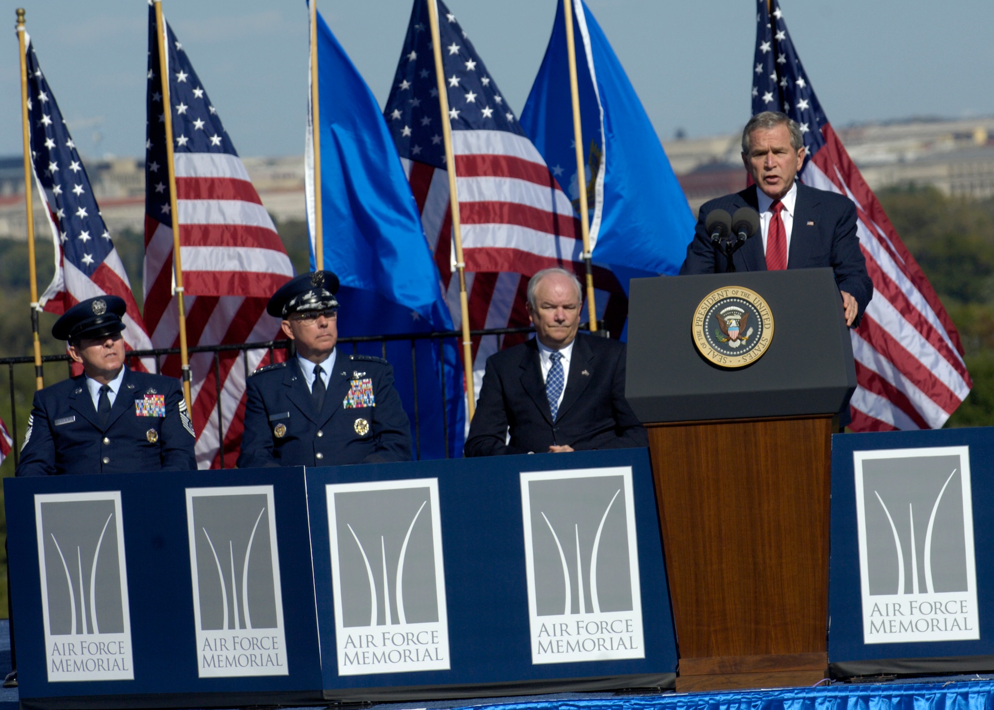 On behalf of all American citizens President George W. Bush accepts the Air Force Memorial during a dedication ceremony at its Arlington, Va. location overlooking the Pentagon on Saturday, Oct. 14, 2006. Looking on are, from left: Chief Master Sgt. of the Air Force Rodney J. McKinley, Air Force Chief of Staff Gen. T. Michael Moseley and  Secretary of the Air Force Michael W. Wynne. Designed by the late James Ingo Freed the memorial with its three soaring spires inspired by the U.S. Air Force Thunderbirds bomb burst manuever, pays tribute to and honors the patriotic men and women of the U.S. Air Force and its predeccessor organizations. An open house will run near the Pentagon in conjunction with the dedication ceremony which will feature performances by the U.S. Air Force Band, the U.S. Air Force Honor Guard drill team, and will culminate with a concert featuring country music performer LeeAnn Womack. (U.S. Air Force photo/Tech. Sgt. Cohen Young) 