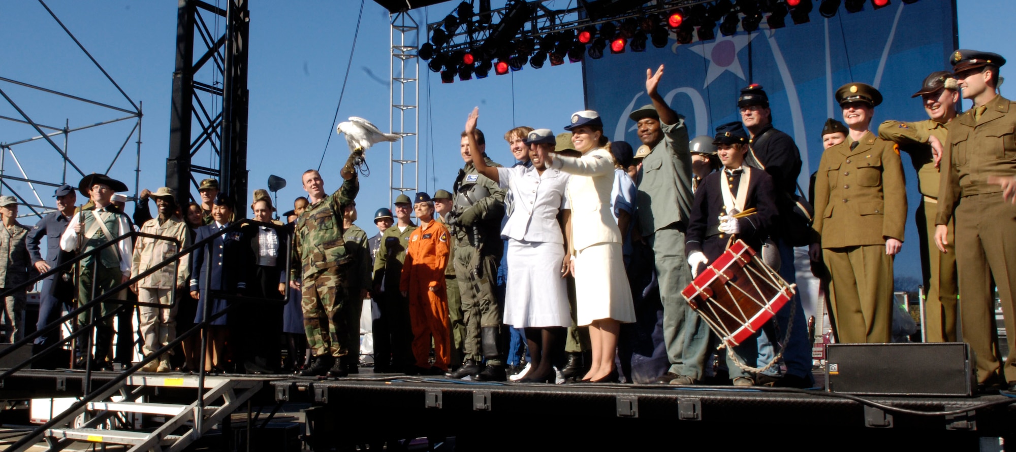Air Force Academy Cadet Second Class Sean Gorden brings Aurora the official Academy mascot onstage to join current and former members of the United States Air Force and its predecessor organizations present a parade of uniforms at an Air Force open house at the Pentagon on Saturday, Oct. 14, 2006. The open house is running in conjunction with the official ceremony to dedicate the Air Force Memorial. President George W. Bush will join Senior Defense Dept. and Air Force officials in a ceremony to present the memorial to the Nation. Designed by the late James Ingo Freed the memorial with its three soaring spires inspired by the U.S. Air Force Thunderbirds bomb burst manuever, pays tribute to and honors the patriotic men and women of the U.S. Air Force and its predeccessor organizations. An open house will run near the Pentagon in conjunction with the dedication ceremony which will feature performances by the U.S. Air Force Band, the U.S. Air Force Honor Guard drill team, and will culminate with a concert featuring country music performer LeeAnn Womack. (U.S. Air Force photo/Senior Airman Desiree L. Andrejcik)