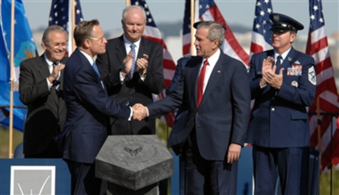 President George W. Bush accepts the Air Force Memorial from Air Force Memorial Foundation Chairman Ross Perot Jr. during a dedication ceremony at its Arlington, Va. location overlooking the Pentagon, Oct. 14, 2006. Looking on are, from left: Secretary of Defense Donald H. Rumsfeld, Secretary of the Air Force Michael W. Wynne, Air Force Chief of Staff Gen. T. Michael Moseley and Chief Master Sgt. of the Air Force Rodney J. McKinley. 