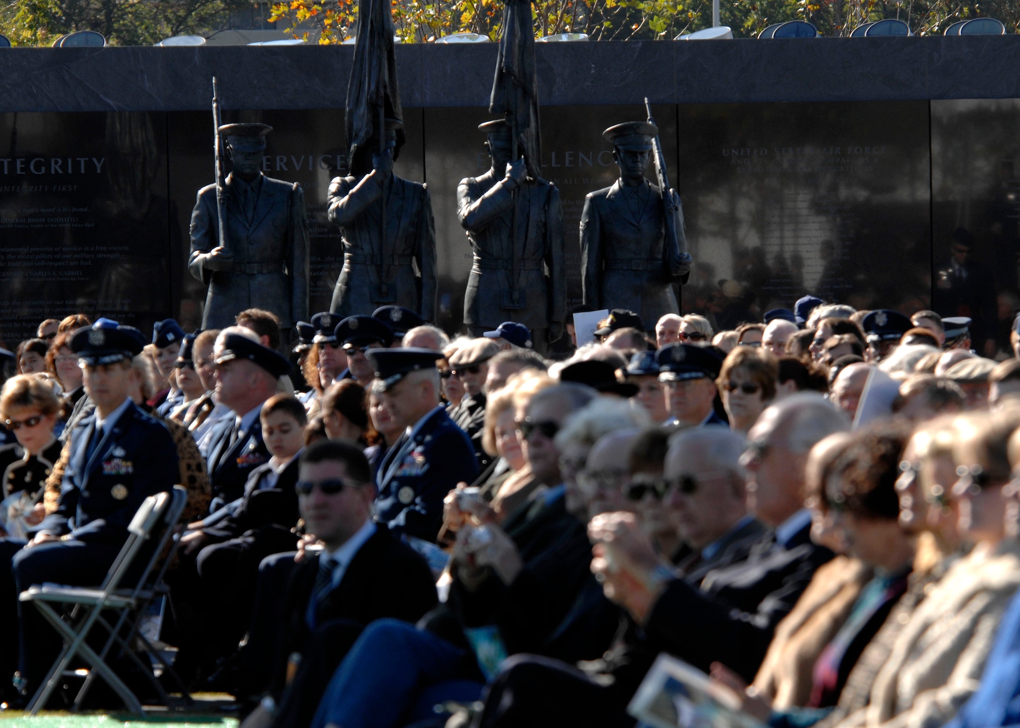 Hundreds sat around and neat the Honor Guard statue at the base of the new Air Force Memorial while Secretary of the Air Force Michael W. Wynne officially closed the Air Force Memorial commemoration with a wreath laying ceremony in Arlington, Va., Oct. 15, 2006. On behalf of all American citizens President George W. Bush accepted the Air Force Memorial from Air Force Memorial Foundation Chairman Ross Perot Jr. during the previous day's dedication ceremony at the base of the Air Force Memorial that overlooks the Pentagon.  Designed by the late James Ingo Freed the memorial with its three soaring spires inspired by the U.S. Air Force Thunderbirds bomb burst manuever, pays tribute to and honors the patriotic men and women of the U.S. Air Force and its predeccessor organizations. An open house was held near the Pentagon in conjunction with the dedication ceremony which featured performances by the U.S. Air Force Band, the U.S. Air Force Honor Guard drill team, and culminated with a concert featuring country music performer LeeAnn Womack. (U.S. Air Force photo/Tech. Sgt. Cohen Young) 