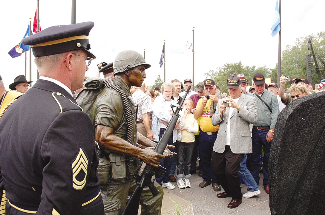 A crowd of visitors takes photos of the newly unveiled Vietnam memorial. According to the official memorial Web site, the South Dakota Vietnam War Memorial takes one soldier, as a symbol of the many South Dakotans who served during this violent conflict, and elevates him to the status they all deserve: brave individuals who served their country at a time when it took as much courage to come home as it did to fight. Two other status rest on the capitol grounds to honor those who served during World War II and the Korean War.