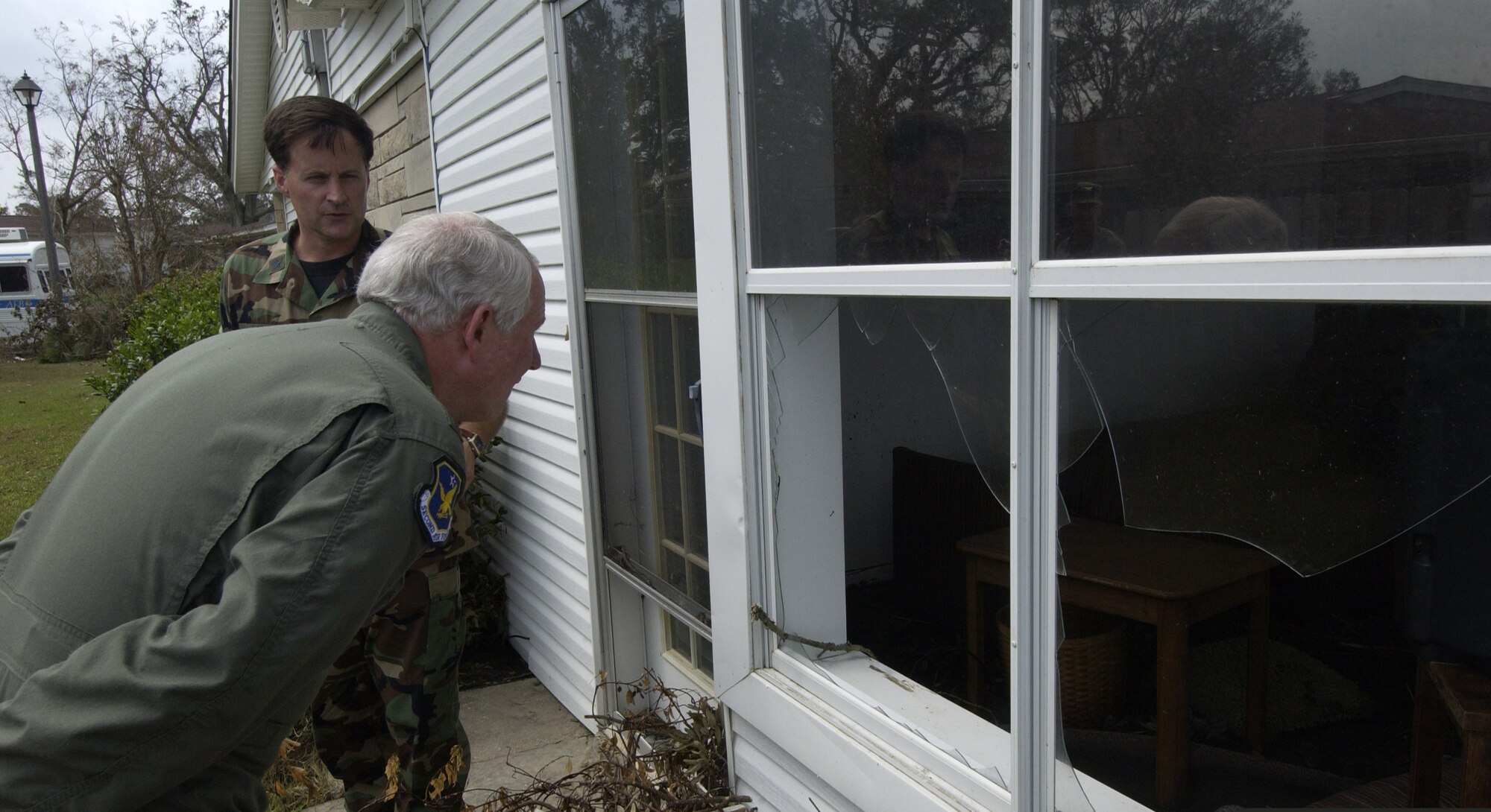 Gen. William R. Looney, III, Air Education and Training Command commander, and Brig. Gen. William T. Lord, 81st Training Wing commander, look into a damaged home in Keesler Air Force Base’s military family housing area. The general made a trip to the base Thursday to assess the hurricane damage first-hand. (Photo by TSgt Jennifer C. Wallis, 1st Combat Camera Squadron)