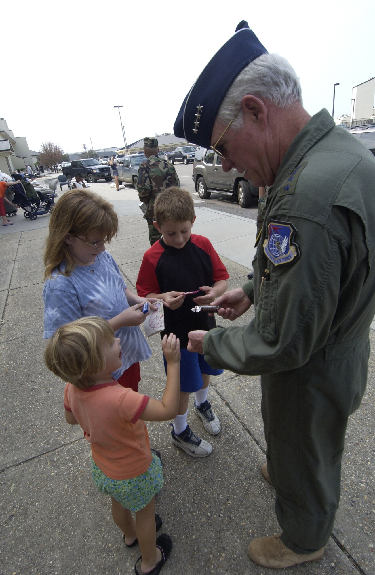 Gen. William R. Looney III, Air Education and Training Command commander, gets a smile from some children at Keesler Air Force Base as he passes out candy during a trip to the base Thursday. General Looney surveyed the damaged caused by Hurricane Katrina and learned first-hand how the command can support. (Photo by TSgt Jennifer C. Wallis, 1st Combat Camera Squadron)