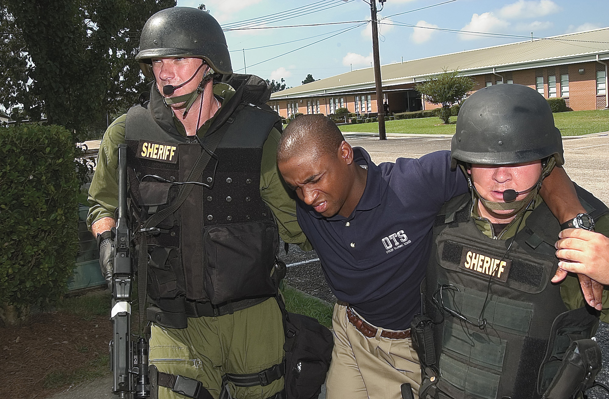 MAXWELL AIR FORCE BASE, Ala. (AETCNS) --Officer trainee Lamar Mister is escorted by SWAT team members out of a middle school after being "shot" by a mock terrorist. The officer trainees from Officer Training School took part in an anti-terrorism drill Saturday tailored after the tragic incident in Beslan, Russia. (U.S. Air Force photo by Senior Airman Jonathan Ortiz-Torres)