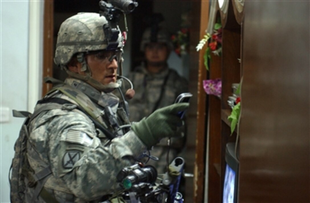 U.S. Army Spc. Chadrick Domino, from Apache Company, 1st Battalion, 23rd Infantry Regiment, 3rd Stryker Brigade Combat Team, checks for contraband during the search of a home in Huriya, Iraq, Oct. 11, 2006. 