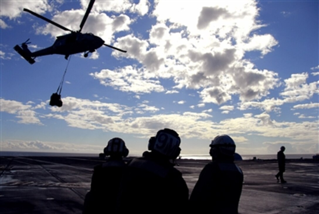Crew members assigned to the "Indians" of Helicopter Anti-Submarine Squadron 6 prepare to direct an SH-60 Seahawk during a vertical replenishment on the flight deck of the nuclear-powered aircraft carrier USS Nimitz, Oct. 13, 2006.