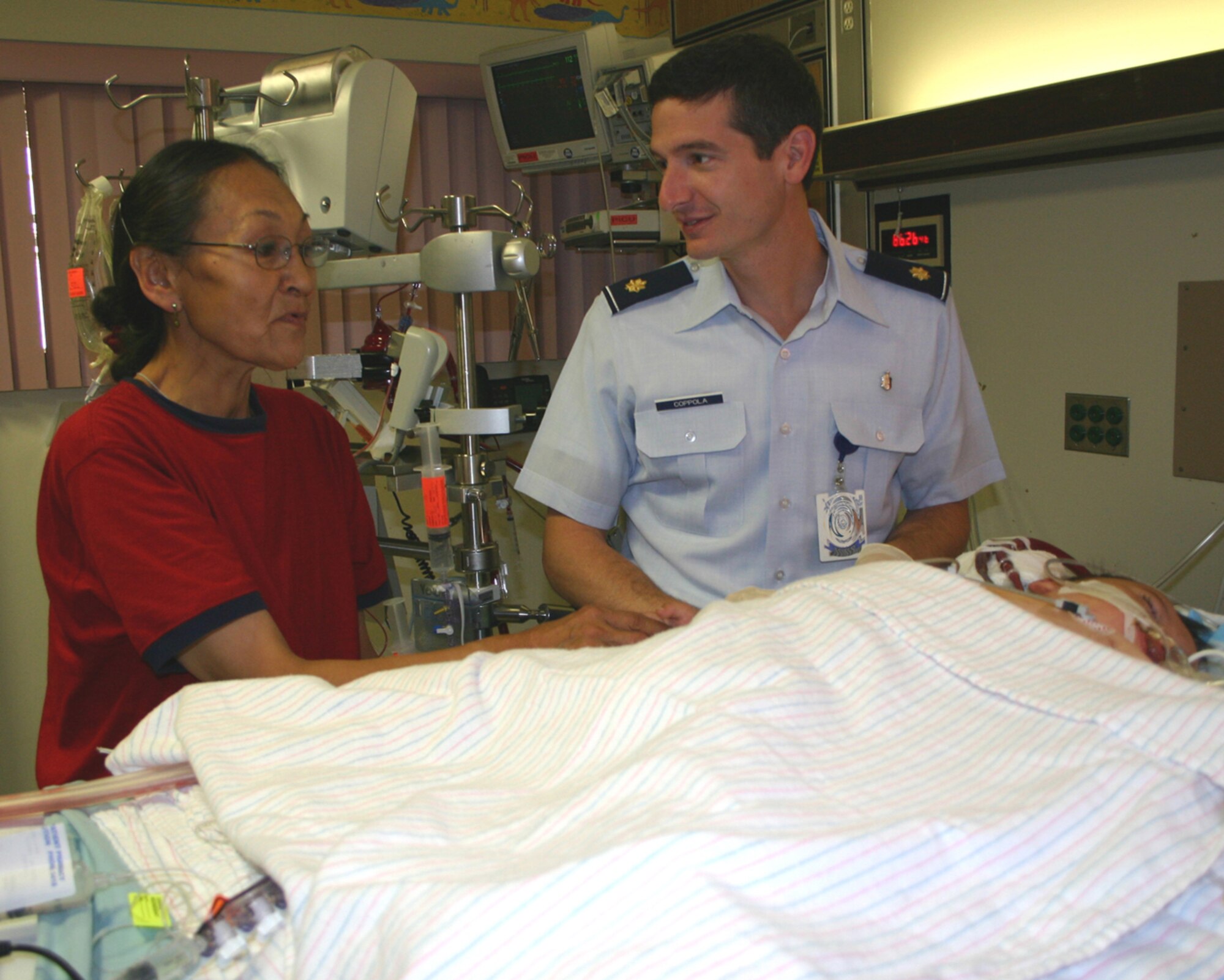 Maj. (Dr.) Christopher Coppola and Dora Hill discuss her son’s status in the Wilford Hall Pediatric Intensive Care Unit. Dr. Coppola, a pediatric surgeon with the 859th Surgical Operations Squadron, was part of the team that flew to Anchorage, Alaska, Aug. 14, in an attempt to save Michael’s life. (Photo by Sue Campbell)