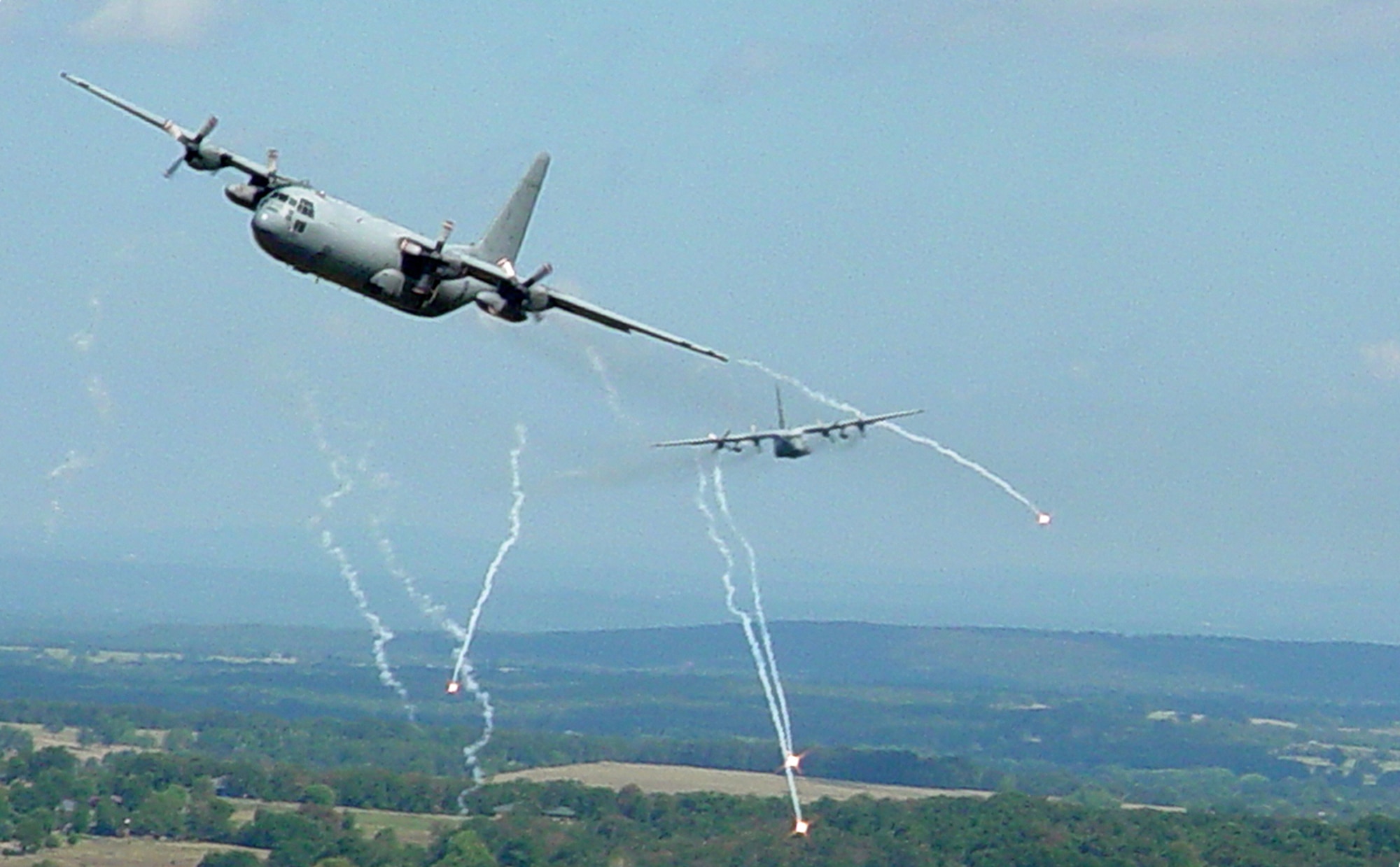A Royal Air Force C-130 and a U.S. Air Force C-130 drop flares over central Arkansas during an interfly exercise. The low-level exercise wrapped up week-long joint training between British and American Airmen. (Photo by Staff Sgt. Norris Chandler)