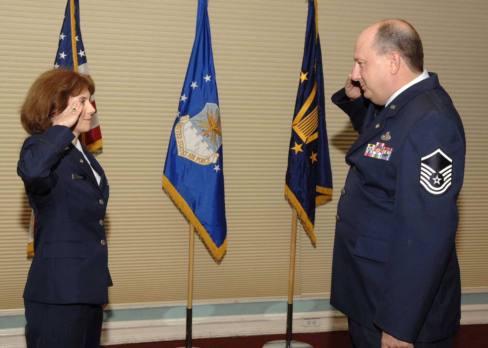 At her retirement ceremony recently, Maj. Alicia Graham reserved her last salute for retired Master Sgt. Jack Pio, who returned the traditional silver dollar she had given him in 1986 to commemorate her first salute. (U.S. Air Force photo/Craig McDonnell) 