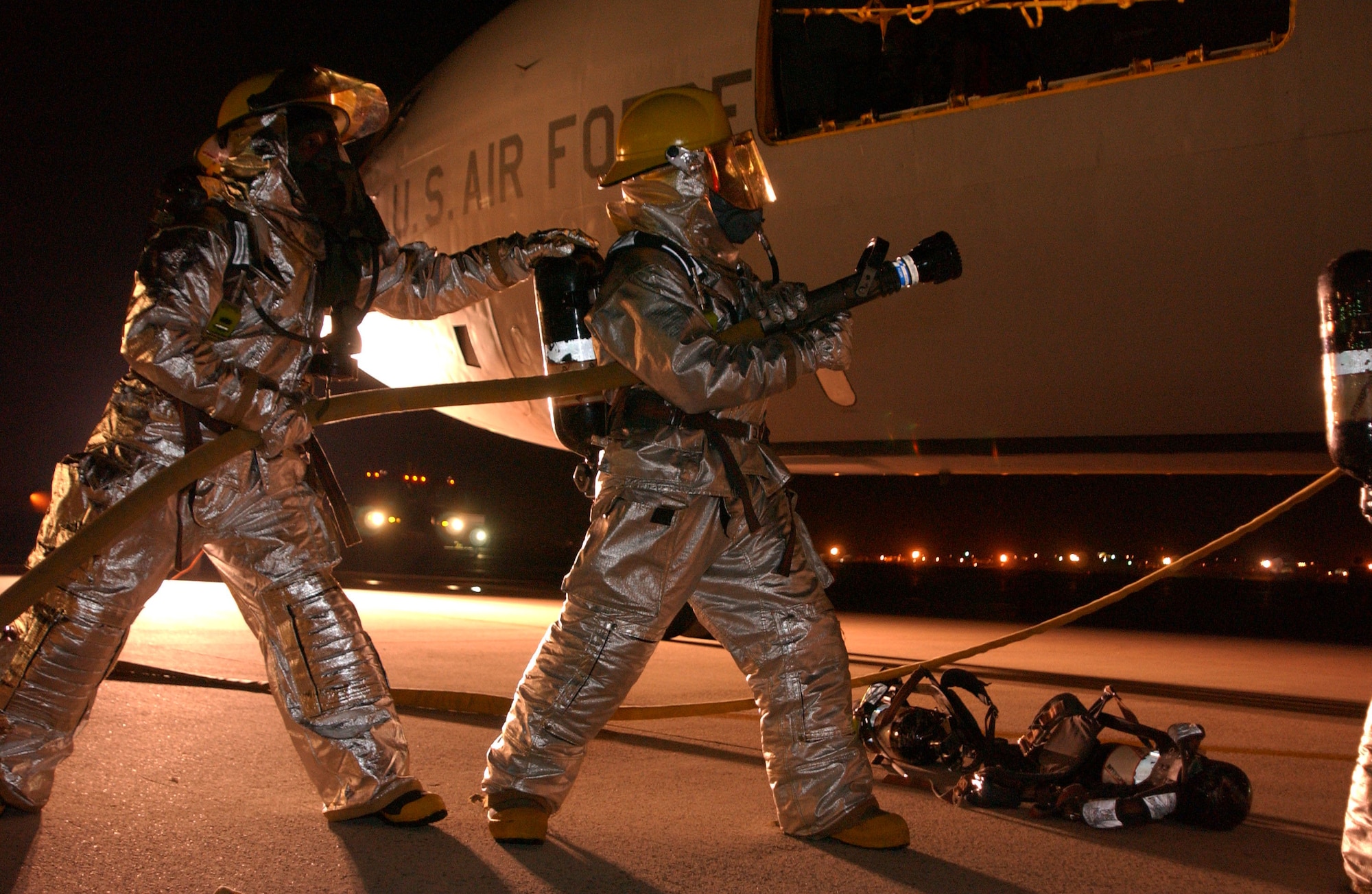 Staff Sgt. John Garcia (left) helps his partner as they simulate extinguishing an aircraft fire during a combat capability exercise Oct. 17 at Kadena Air Base, Japan. The 18th Wing exercise from Oct. 13 to 19 tests the wing's ability to respond to a wartime situation. Sergeant Garcia is a firefighter with the 18th Civil Engineer Squadron . (U.S. Air Force photo/Airman Kelly Timney)