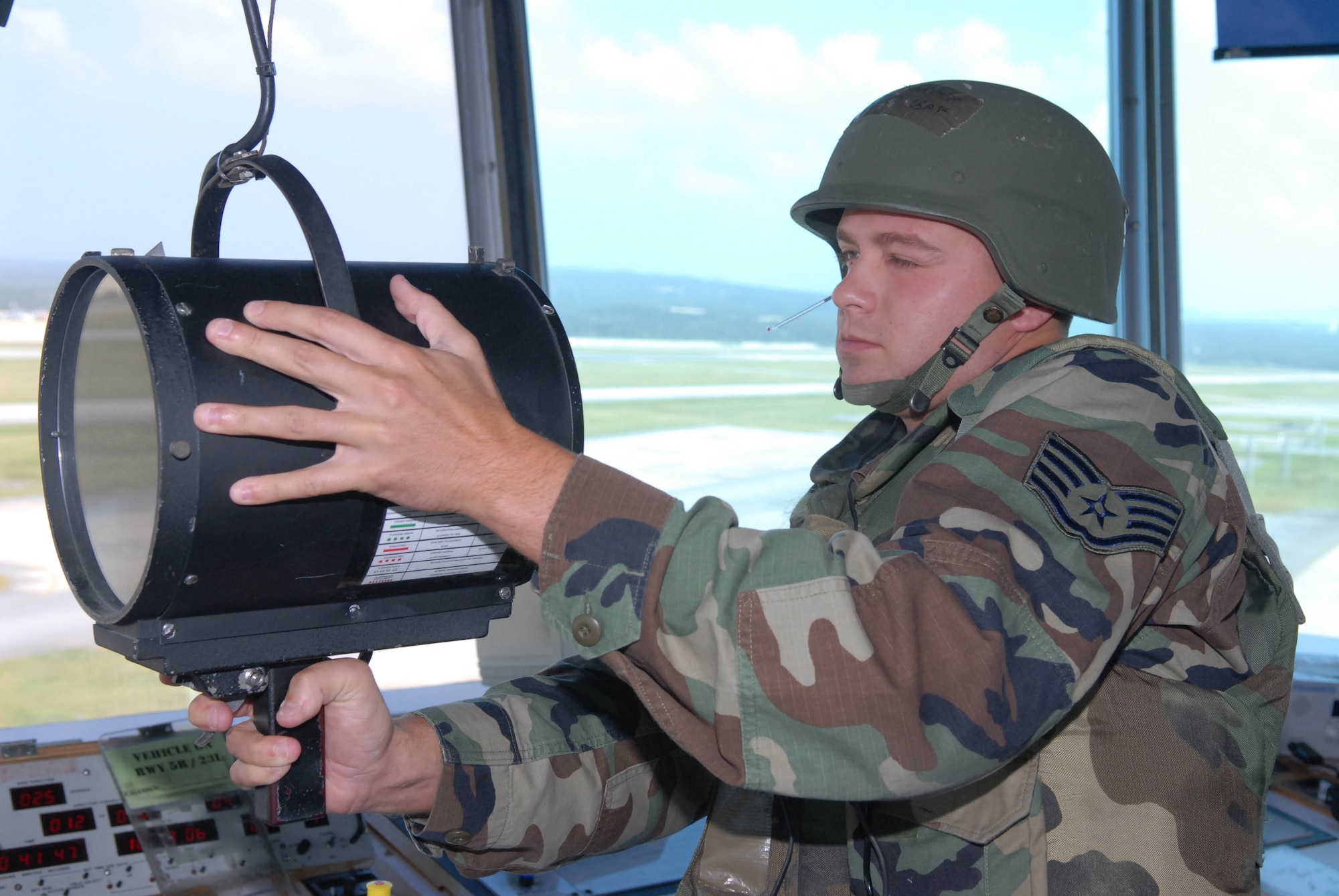 Staff Sgt. Davis Christopher flashes a light gun signal from the air traffic control tower to approaching aircraft during an exercise Oct. 17 at Kadena Air Base, Japan. The light gun signal is used when an aircraft has lost radio communications with the control tower. The 18th Wing exercise from Oct. 13 to 19 tests the wing's ability to respond to a wartime situation. Sergeant Christopher is assigned to the 18th Operations Squadron. (U.S. Air Force photo/Tech. Sgt. Dave DeRemer) 
