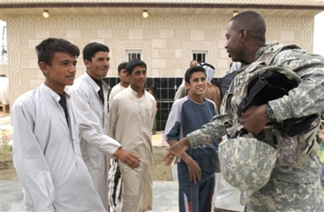 A group of Iraqi boys greet U.S. Army Sgt. Maj. Benny Hubbard with handshakes prior to the ribbon cutting ceremony for the Salah Hadi Obid Elementary School in Afak, Iraq, on Oct. 11, 2006. The construction of the school was funded, contracted and inspected by the U.S. Army Corps of Engineers. 
