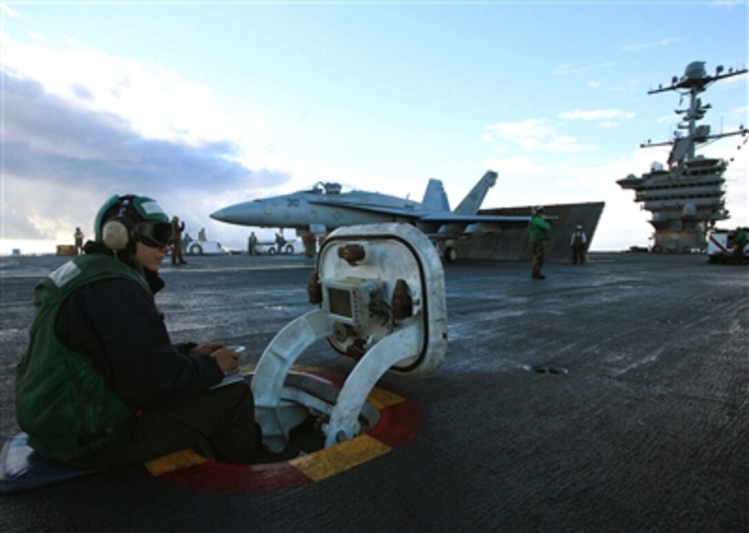 U.S. Navy Airman Saul Arrass calculates wind speed to prepare the center deck for aircraft launch, Oct. 13, 2006, aboard the USS John C. Stennis in the Pacific Ocean.