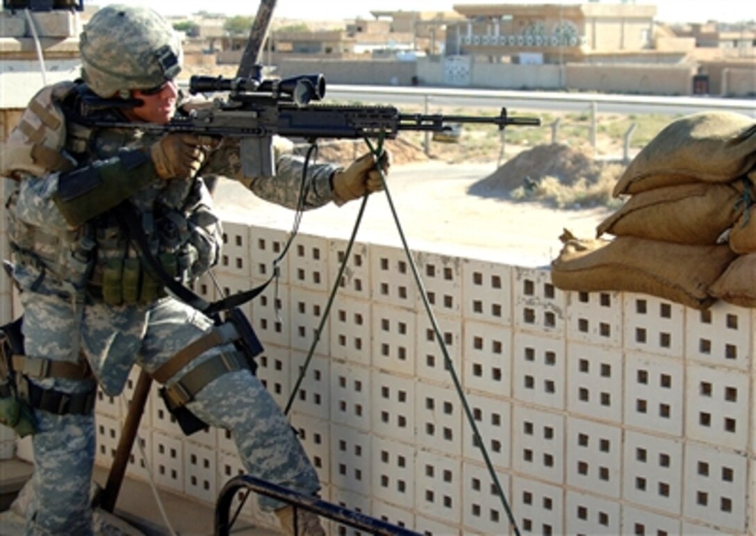 U.S. Army Sgt. Chris Walsh checks his weapon's scope while performing overwatch security in Sekeik, Iraq, Oct. 16, 2006.  Walsh is from Wyoming National Guard Police Training Team. 