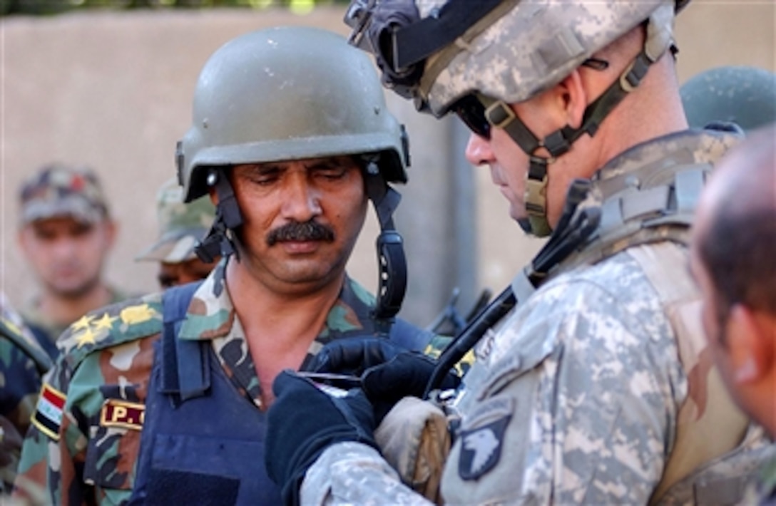 Brig. Gen. Ra'ad, 6th Brigade, 2nd National Police Division, and Lt. Col. Gregory Butts, commander, 2nd Battalion, 506th Infantry Regiment, examine false identification cards found on an individual carrying a large amount of U.S. dollars who was trying to evade the cordon in Baghdad, Iraq, Oct. 17, 2006. 