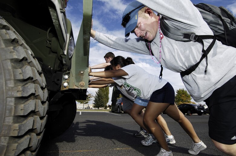 FAIRCHILD AIR FORCE BASE, Wash. -- 1st. Lt. Matthew Beck, 92nd Comptroller Squadron financial services flight commander, pushes a military Humvee with his team as part of the 92nd Services Squadron’s contest, the Great Race, Oct. 13. (U.S. Air Force photo/Senior Airman Anthony Ennamorato)