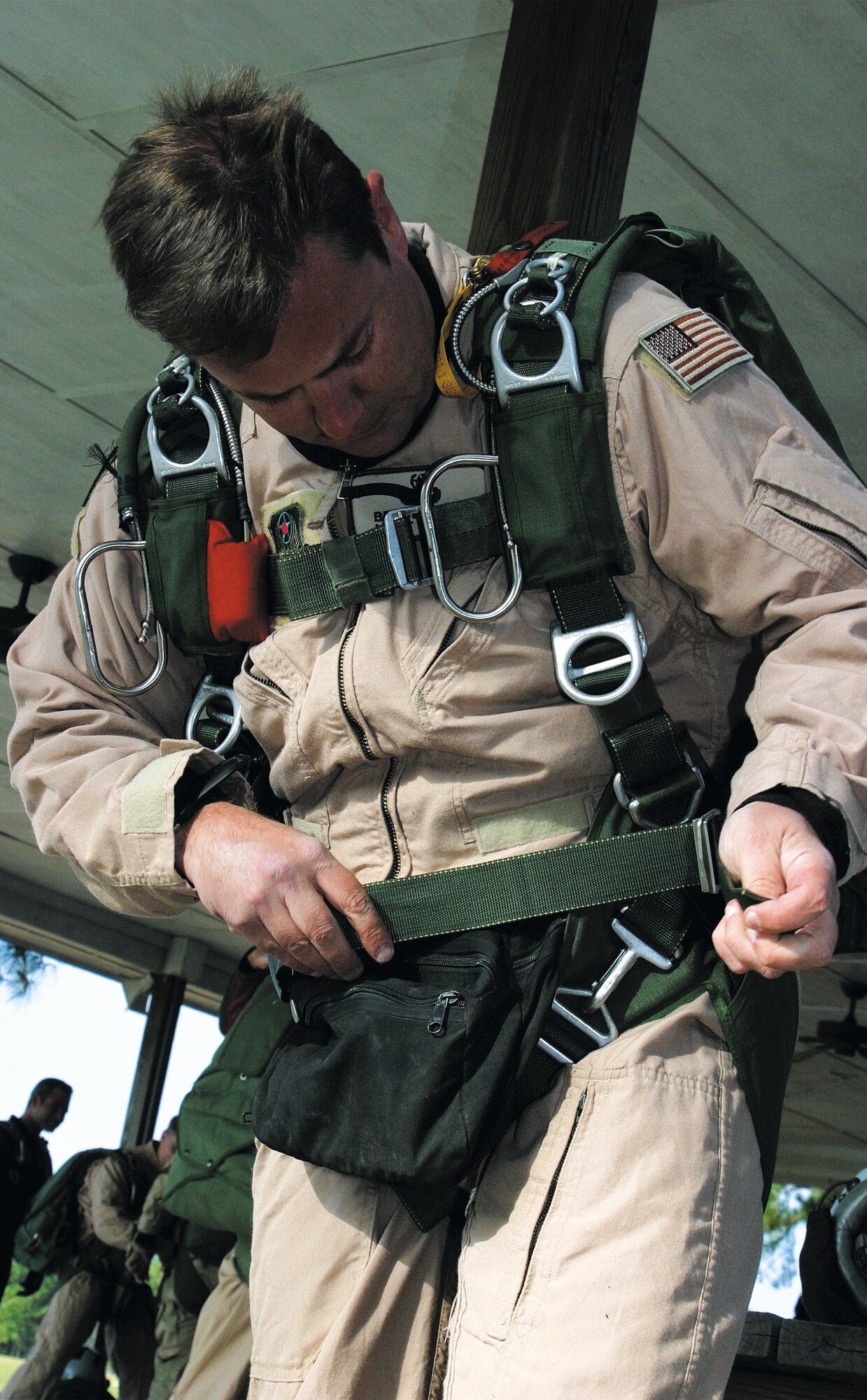 Master Sgt. Bruce Hurst, 21st Special Tactics Squadron combat controller, straps on his military parachute before boarding a prop plane and performing a HALO jump at Raeford Drop Zone Oct. 13. (U.S. Air Force photo/Senior Airman Stacia Zachary)